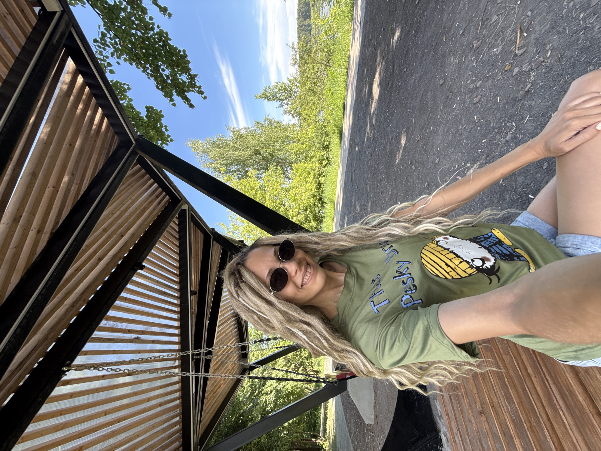 Woman in green shirt smiles on bench