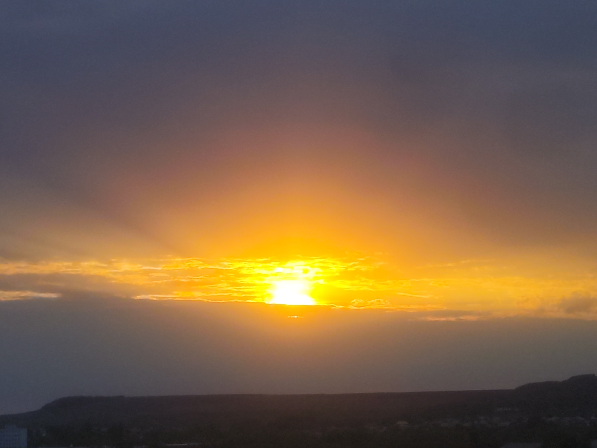 Sunset documented through clouds and measuring device at unknown location