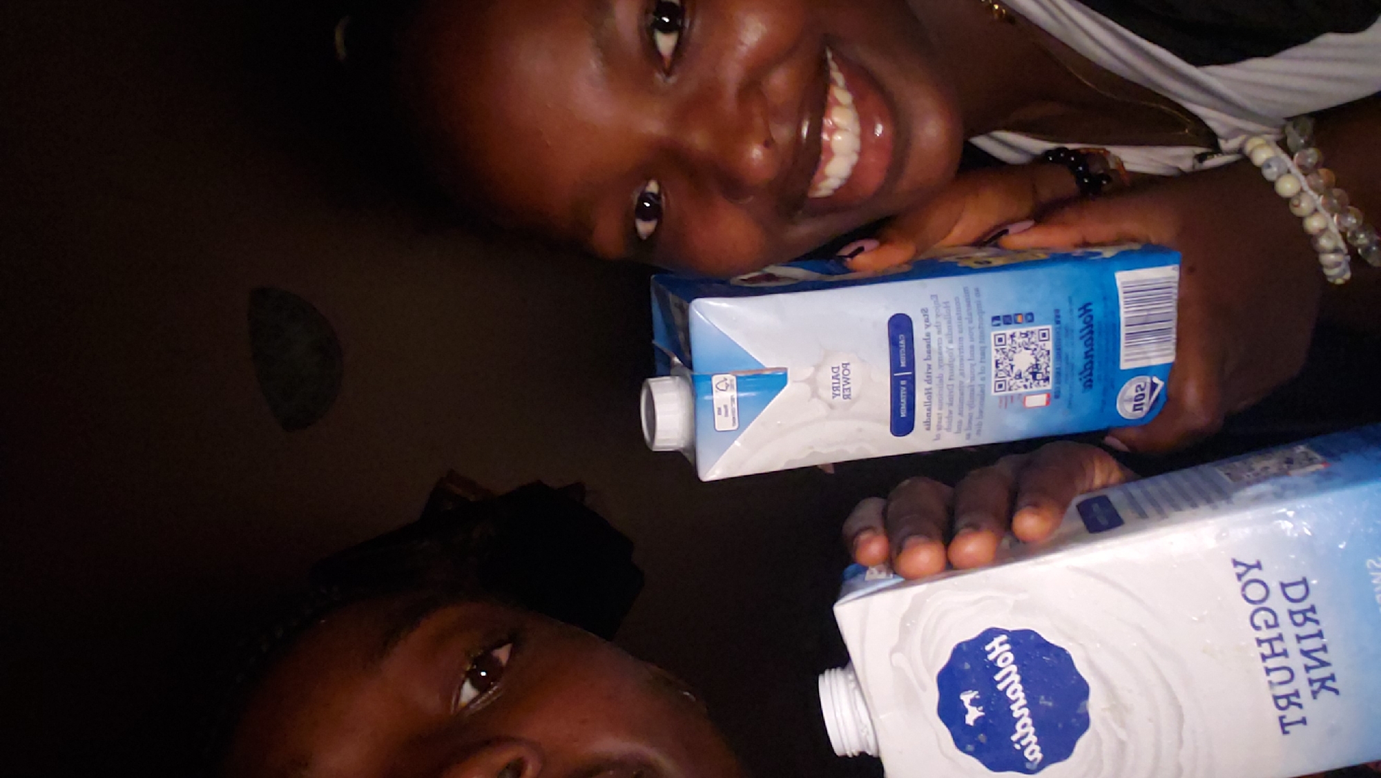 Two people photographed with dairy cartons in Rido, Nigeria