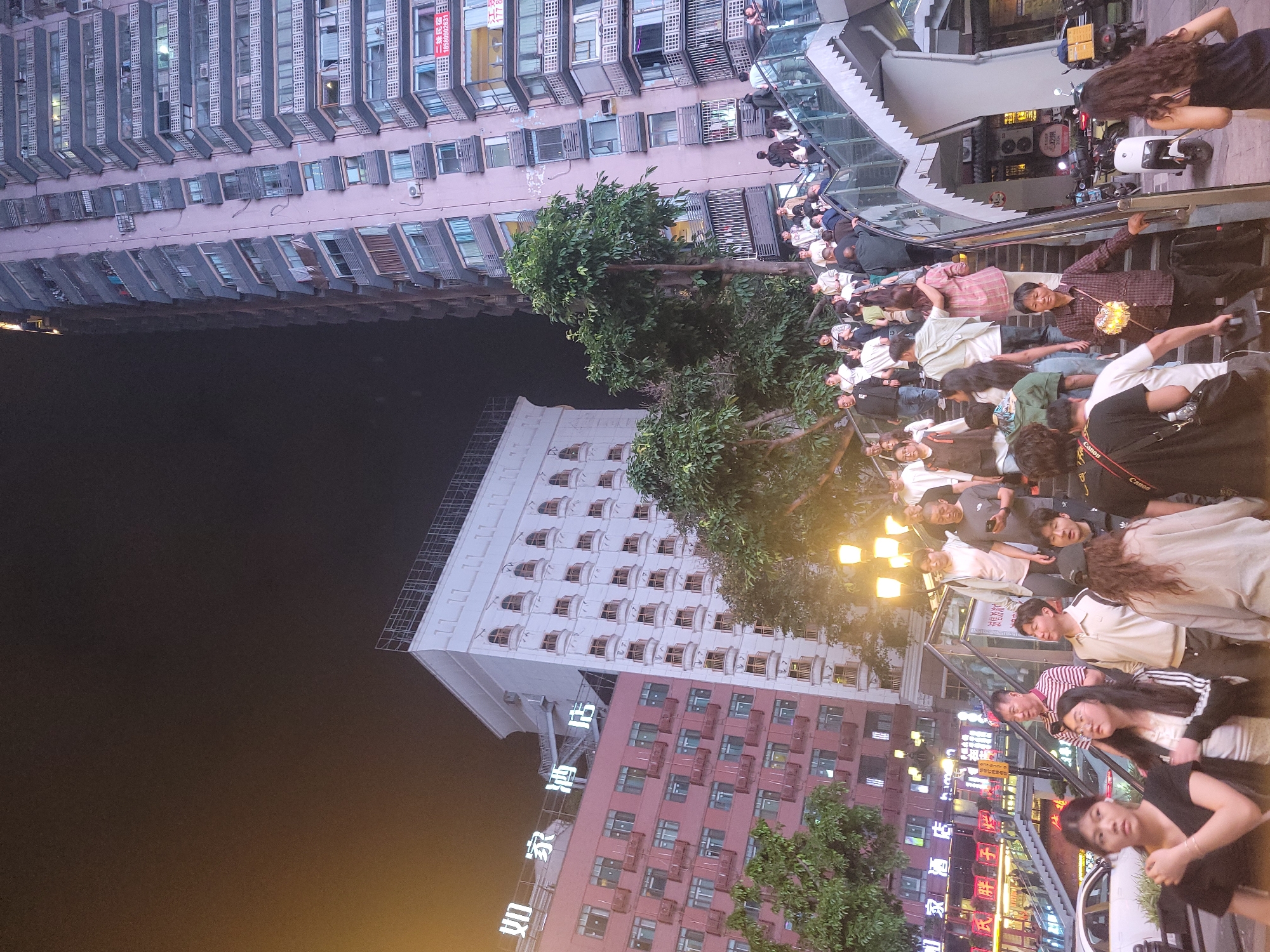 Nighttime crowds gather in illuminated Yuzhong District streets
