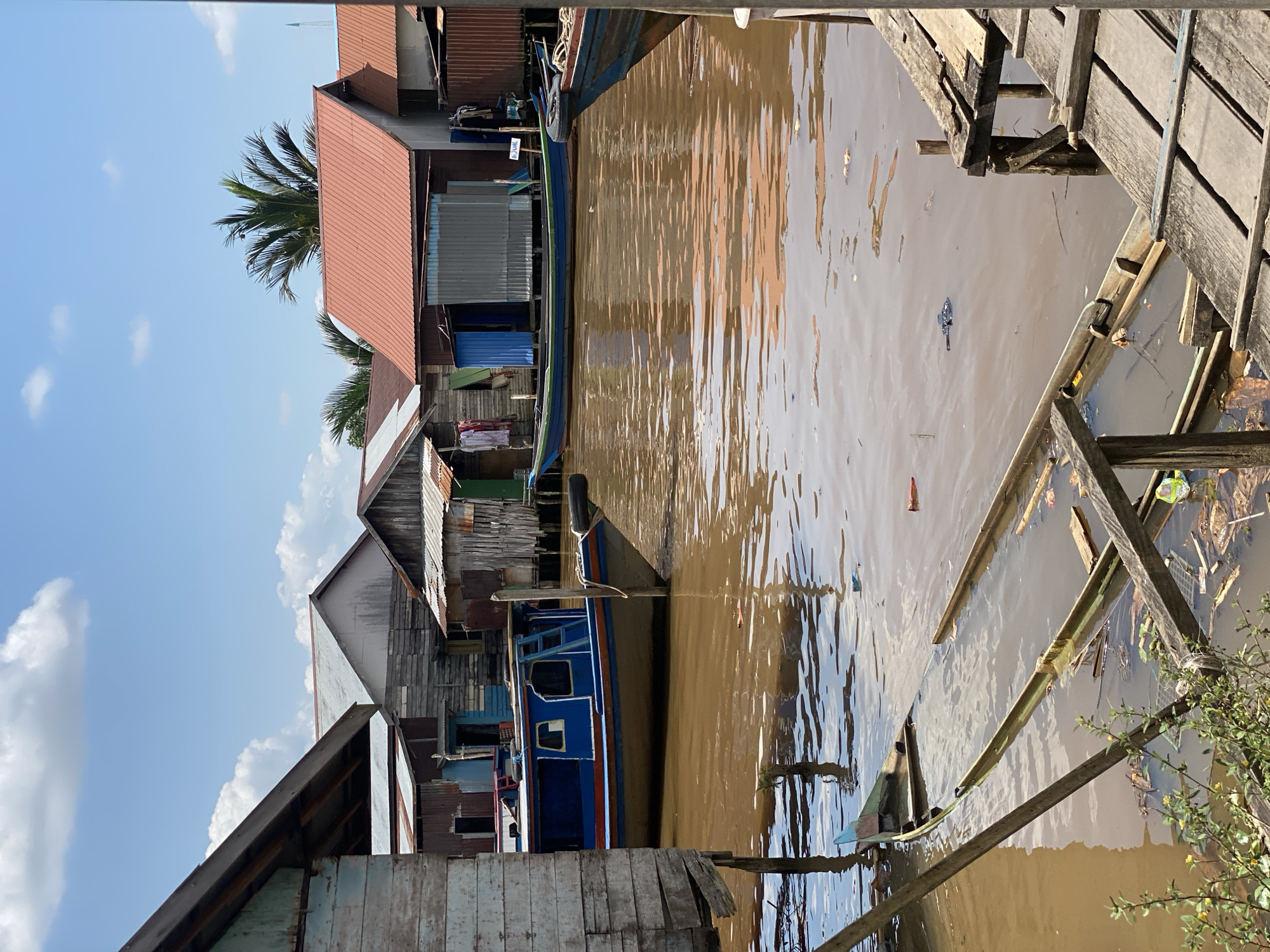 Stilted village houses along a muddy river in Berangas Timur