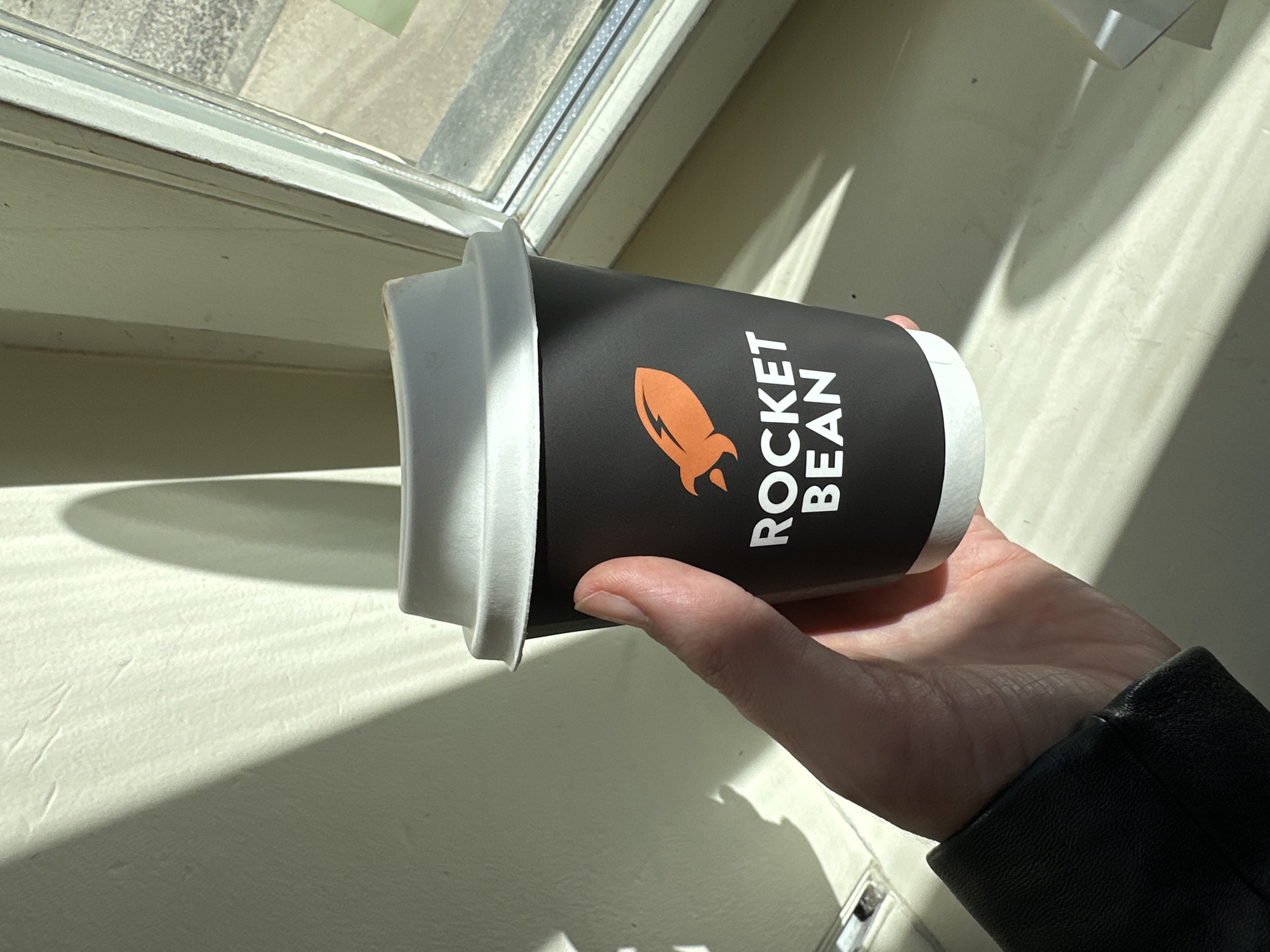 Coffee cup with rocket logo photographed in Riga