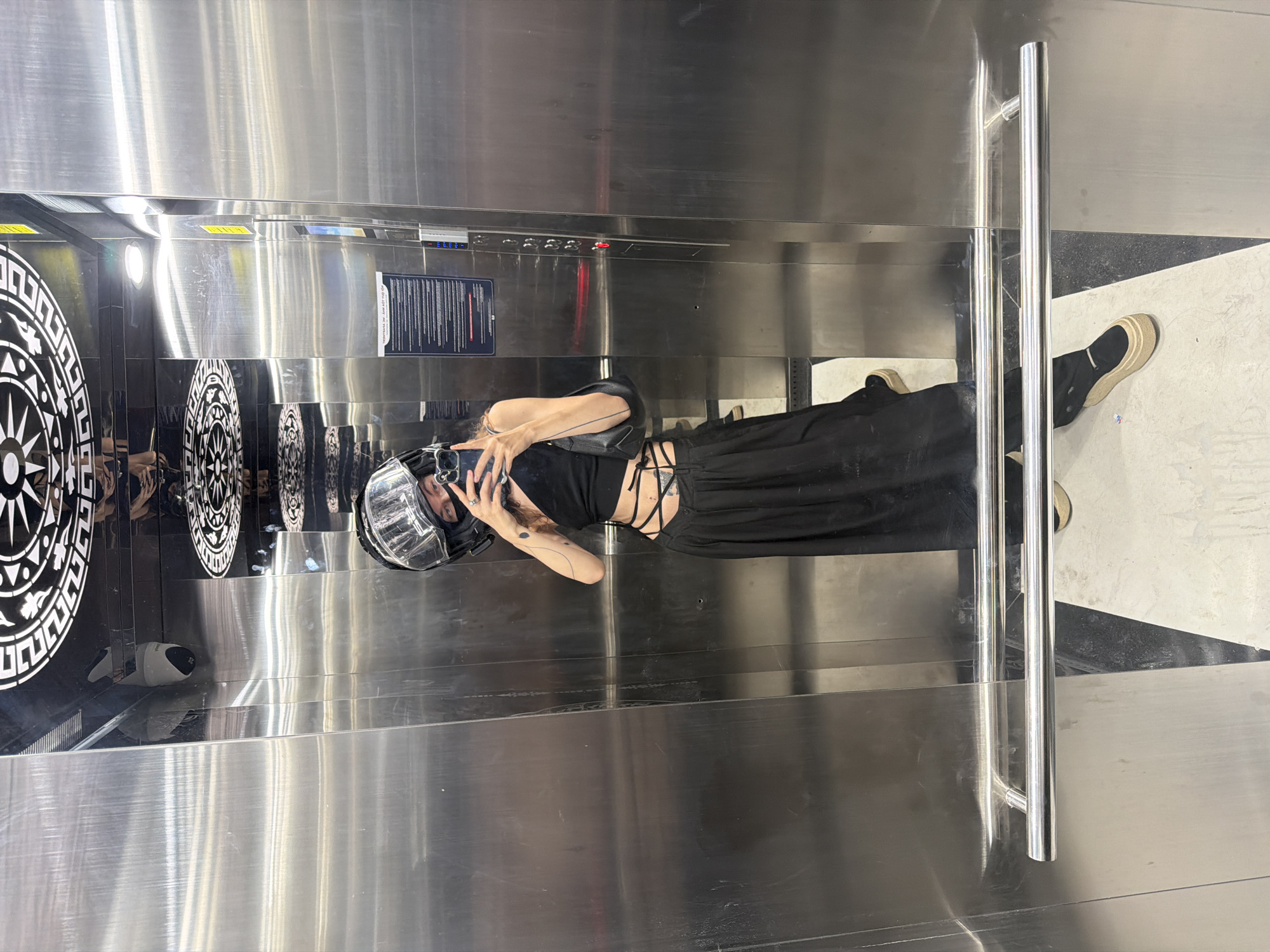 Woman in clear helmet photographs inside elevator in Đà Nẵng