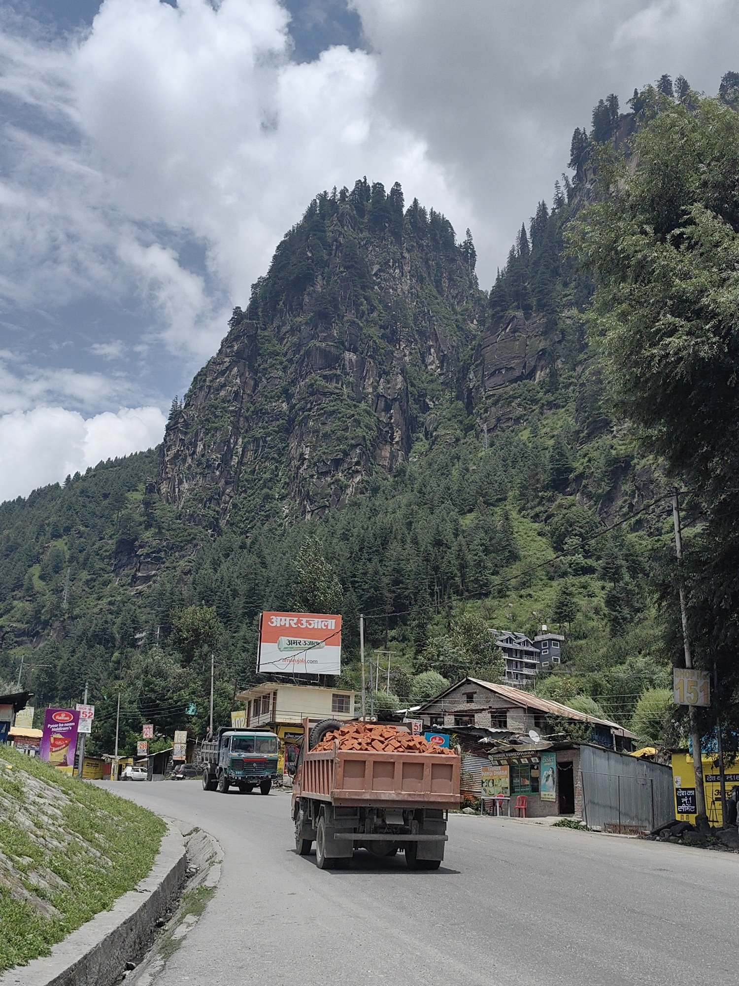 Trucks moving through Bahang's mountain roads on a cloudy morning