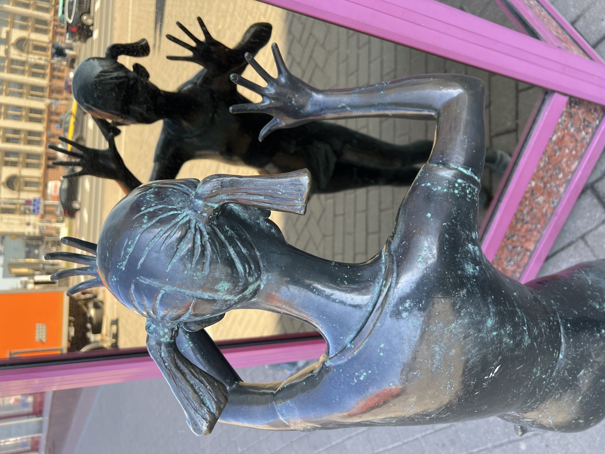 Bronze statue reflected in decorative mirror on Minsk street
