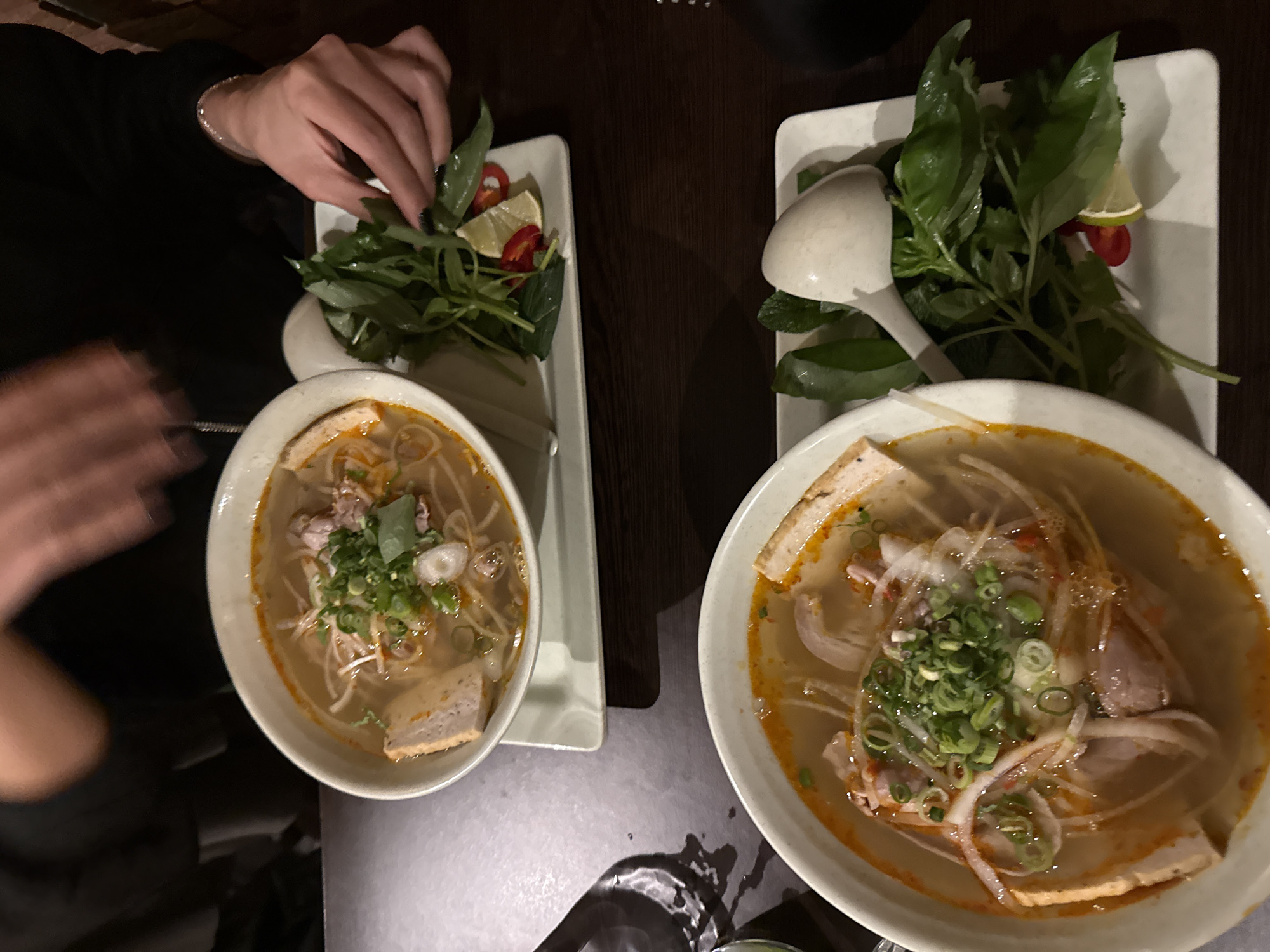 Diner customizes Vietnamese soup with herbs at London restaurant