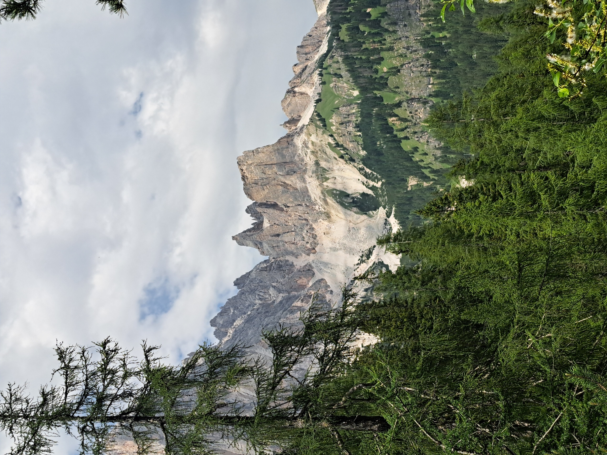 Hiking a mountain trail past forest, peaks, and an old bunker