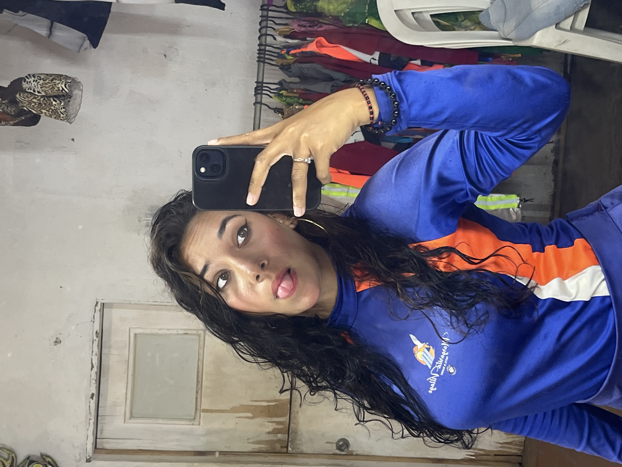 Woman takes selfies in cluttered room in Porlamar