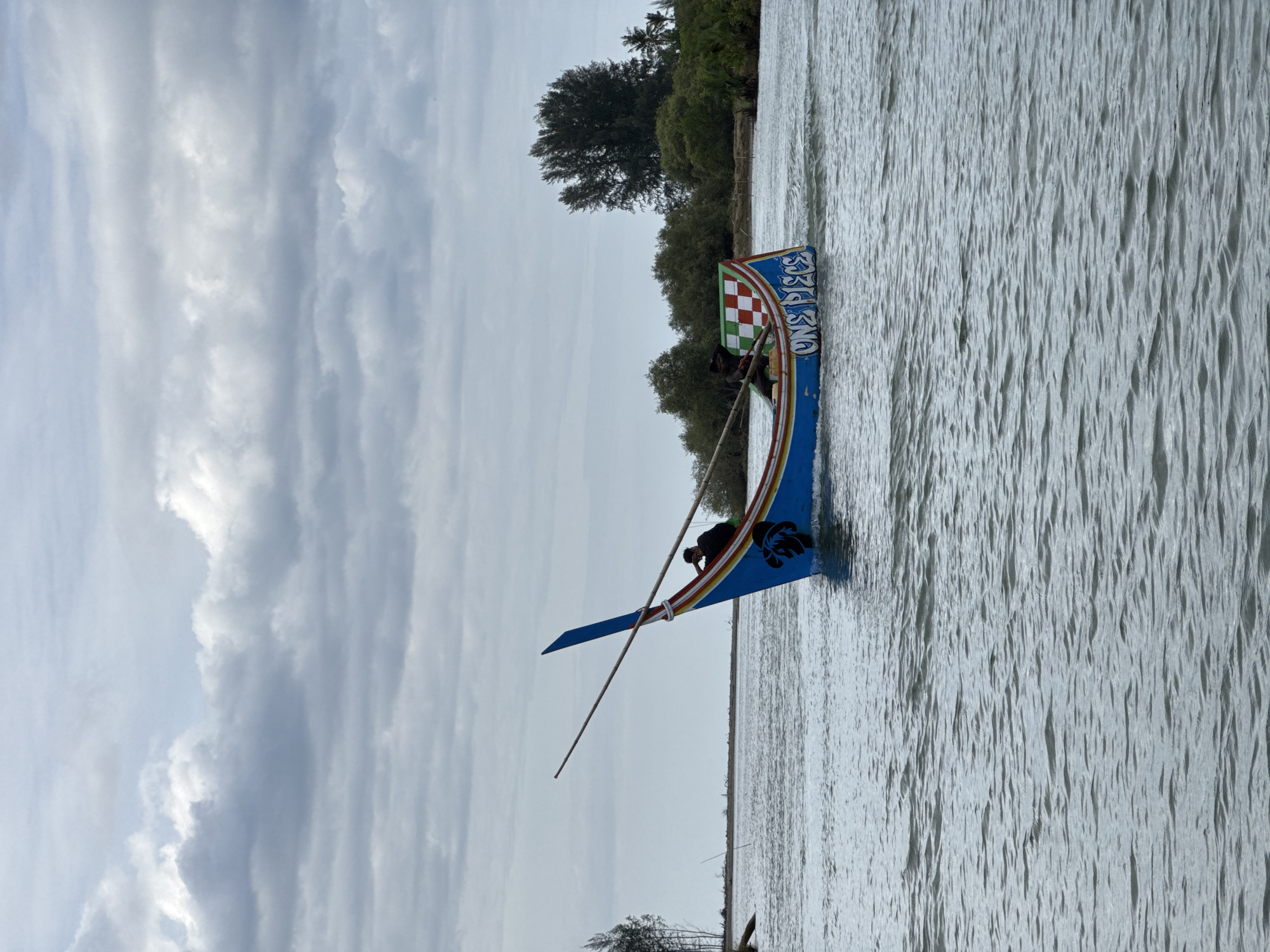 Colorful traditional longboats navigating a river in Rhieng Mancang