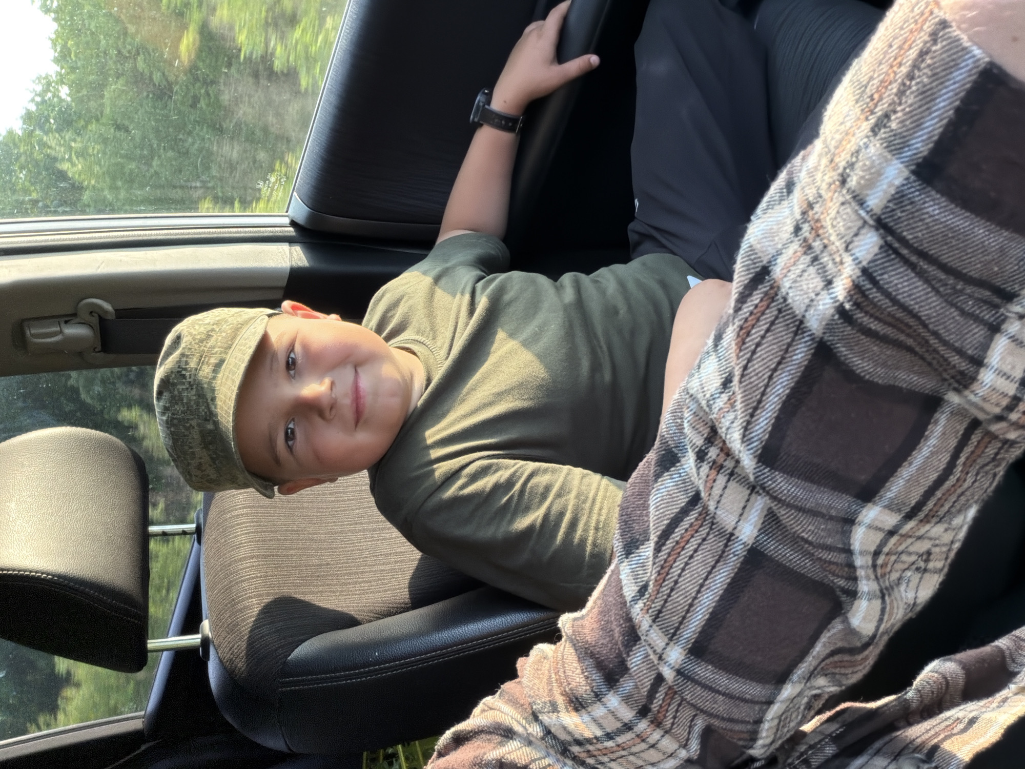 Boy photographed smiling in car backseat in Sergeyevka, Russia