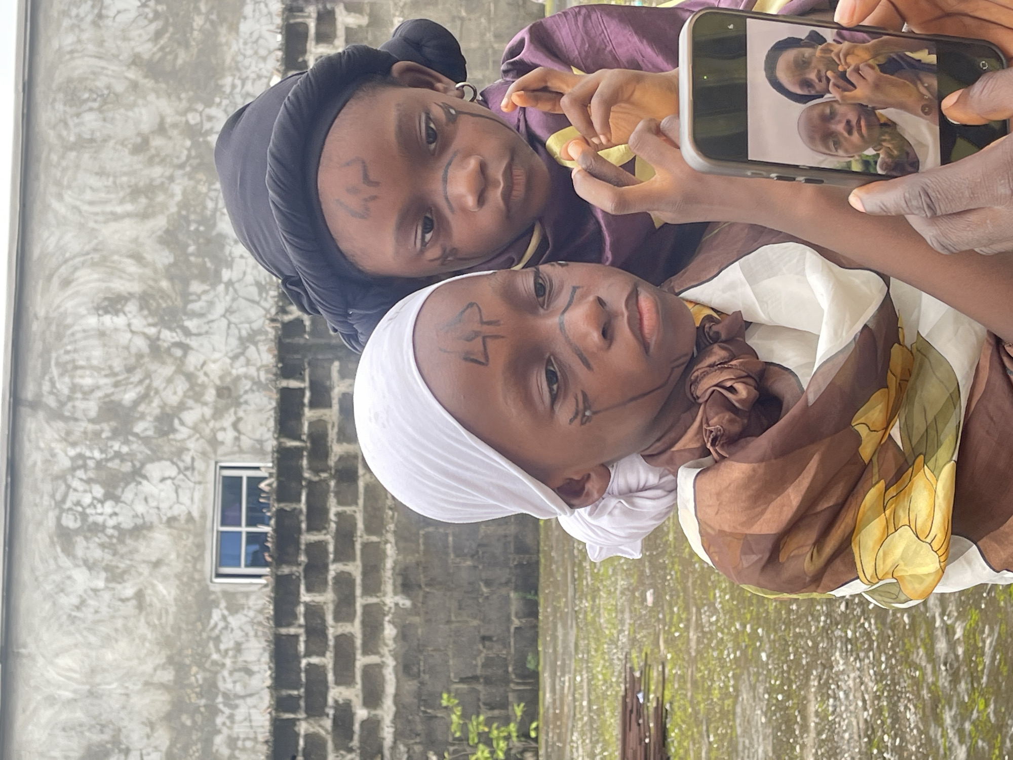 Children in traditional dress with face paint documented in Ado