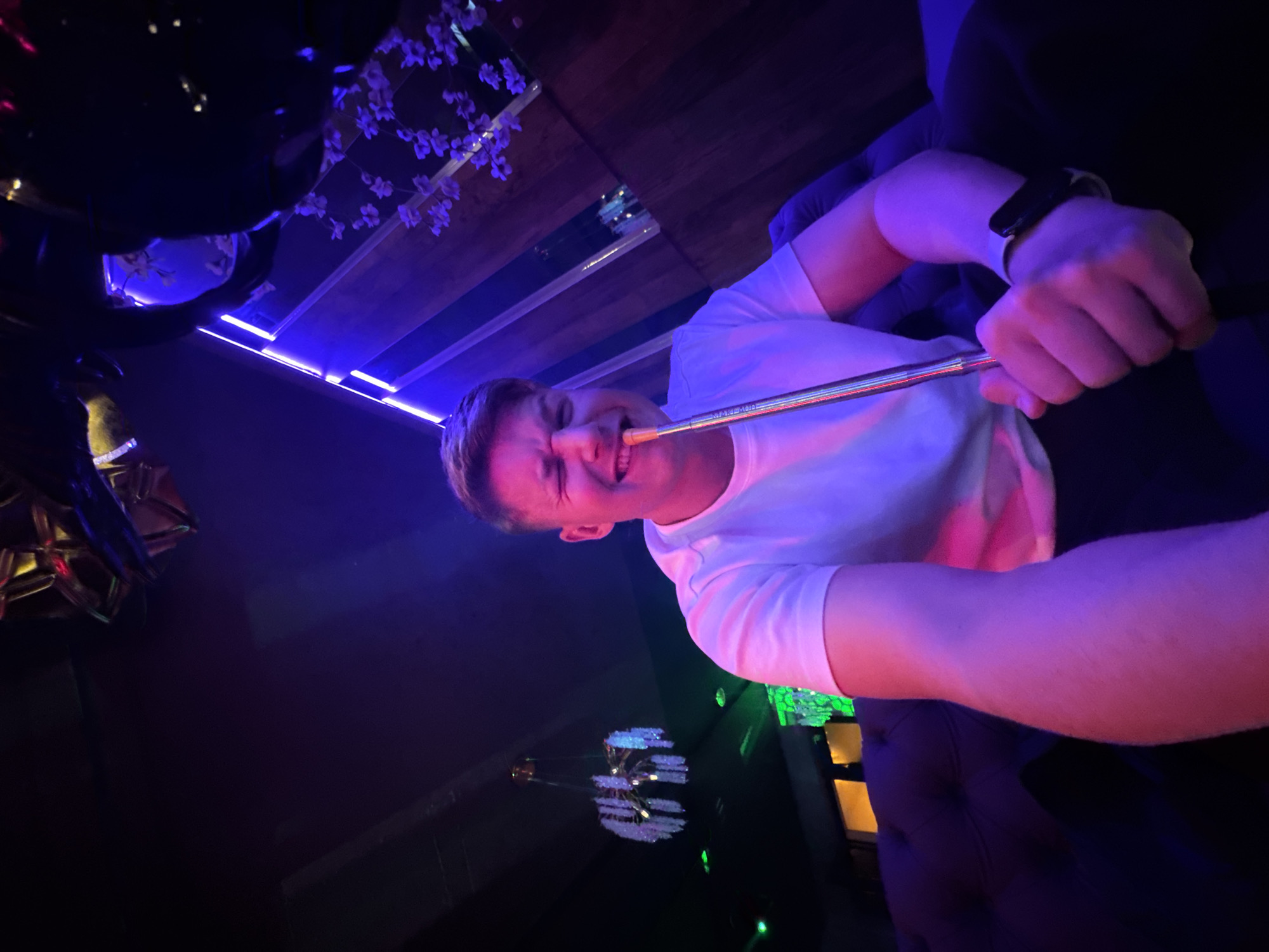 Person enjoys hookah at neon-lit nightclub in Burgas, Bulgaria