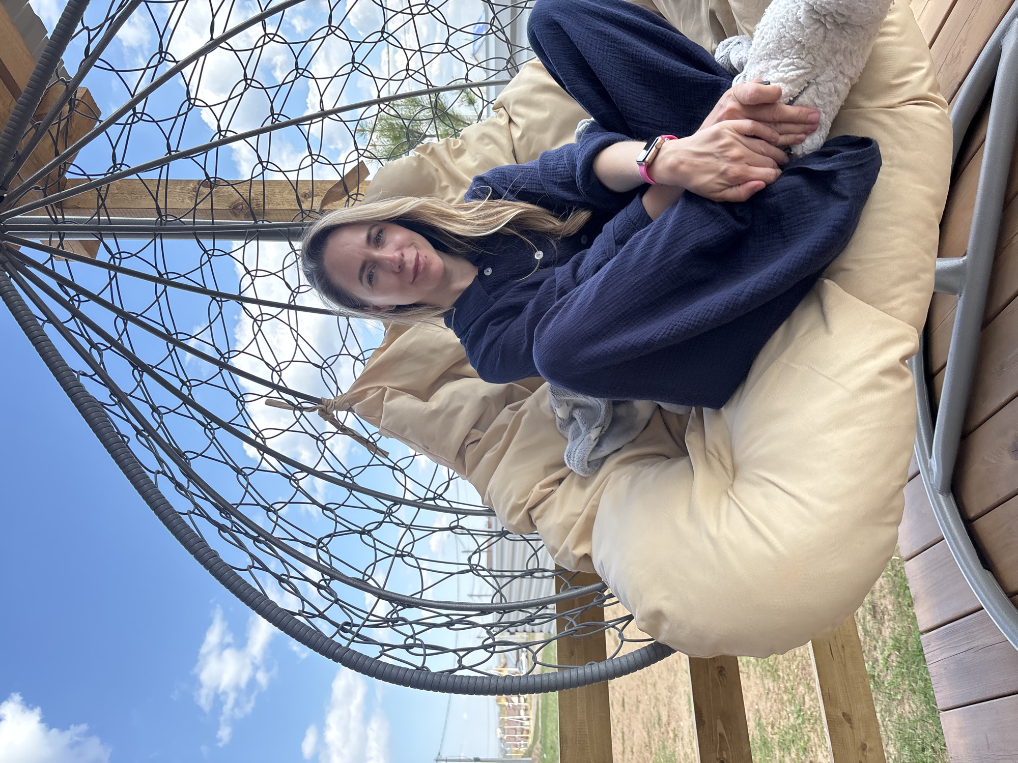 Woman relaxes in hanging chair, poses with roses in Chaikovsky