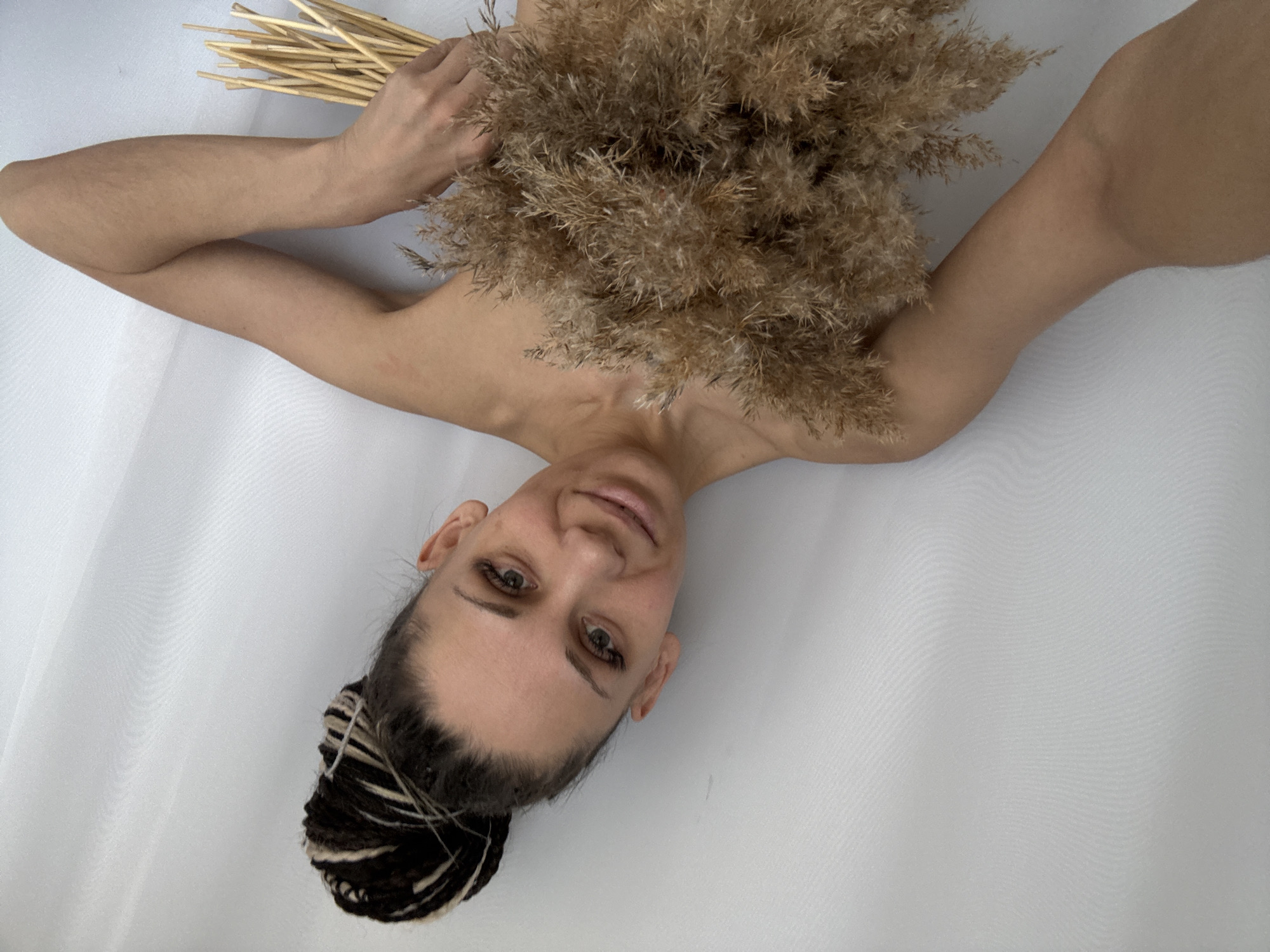 Woman poses with dried grass in artistic photo session