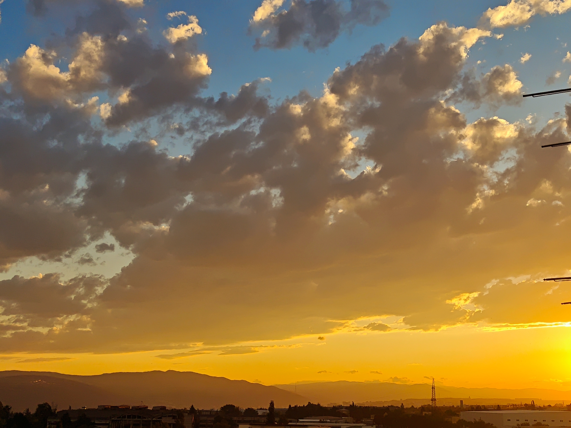 Tbilisi skyline at golden hour, clouds and crescent moon