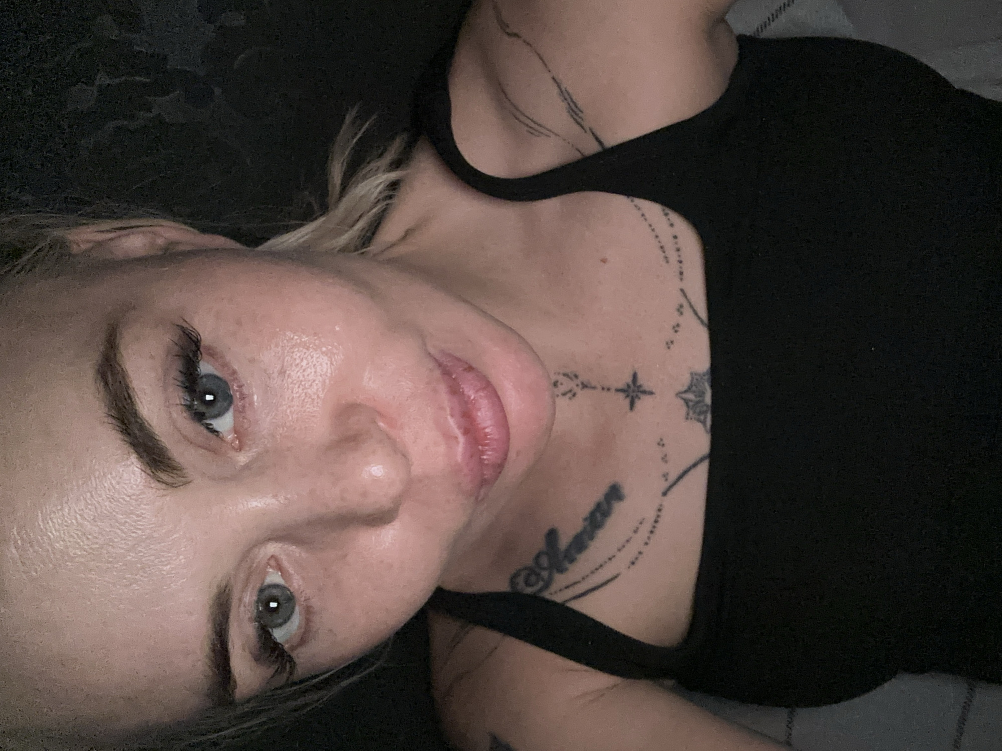 Woman documents extended selfie session in dark indoor setting