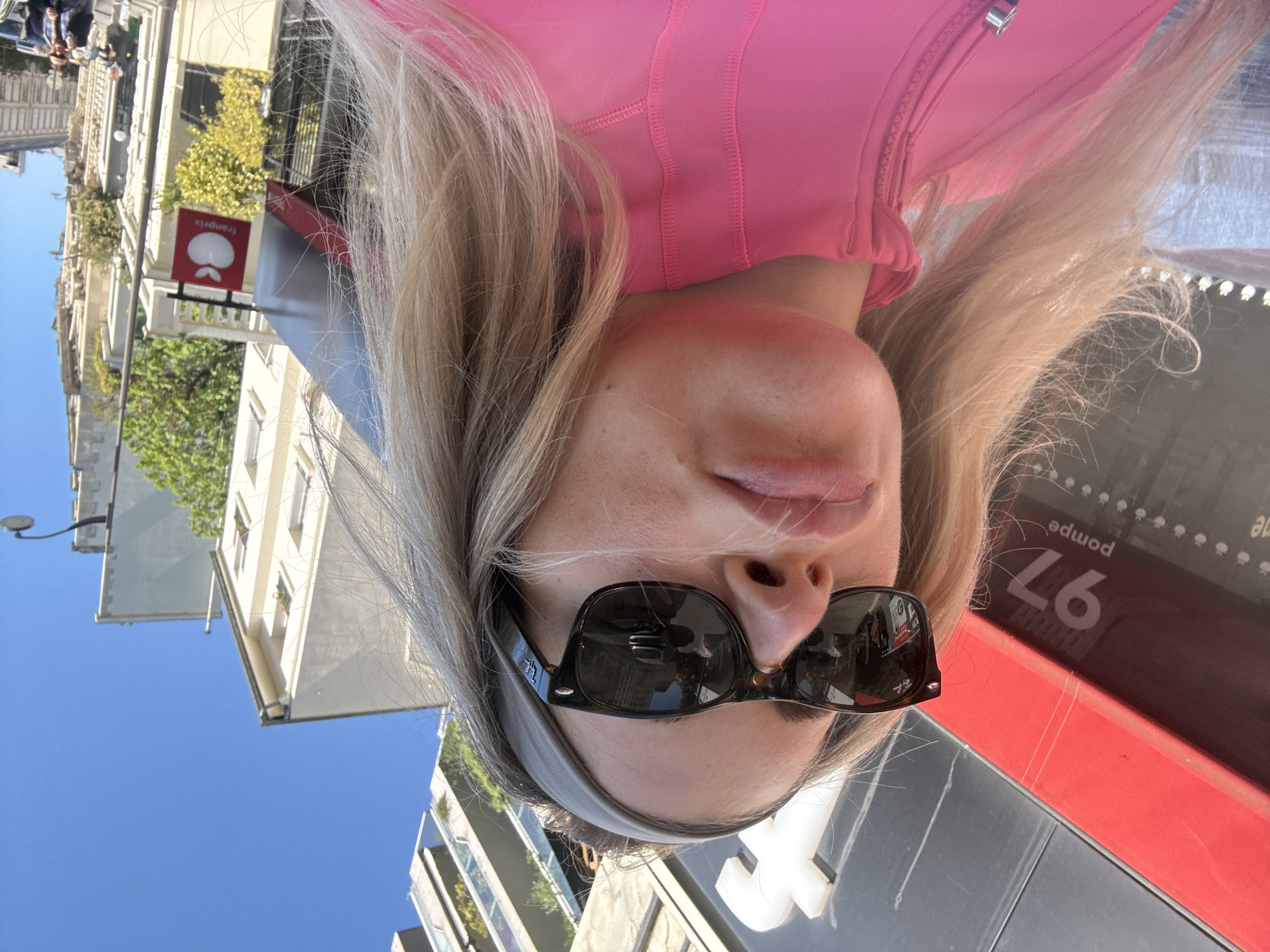 Person takes sunny selfies in Paris urban setting