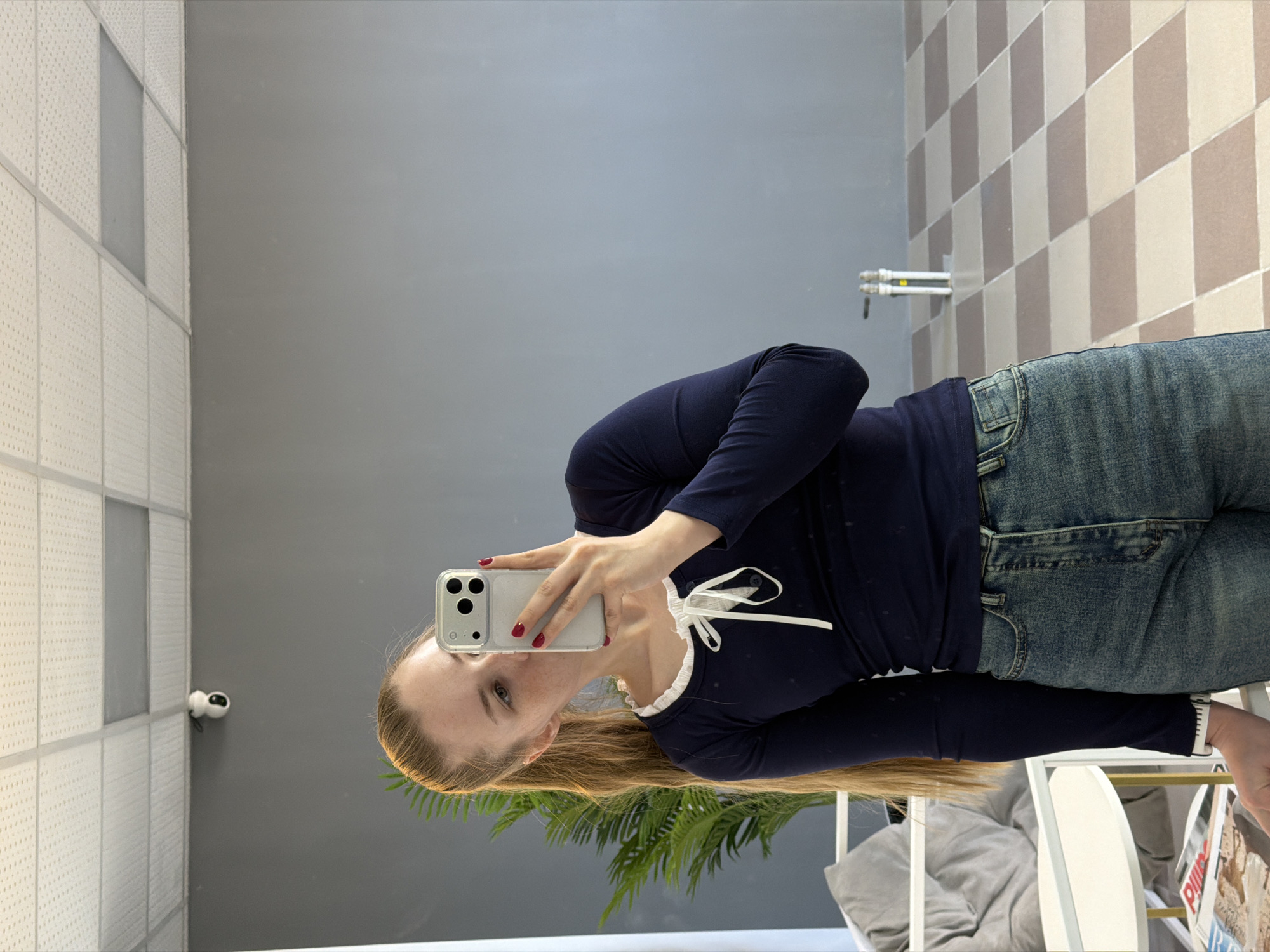 Woman takes multiple mirror selfies in Berezniki office space