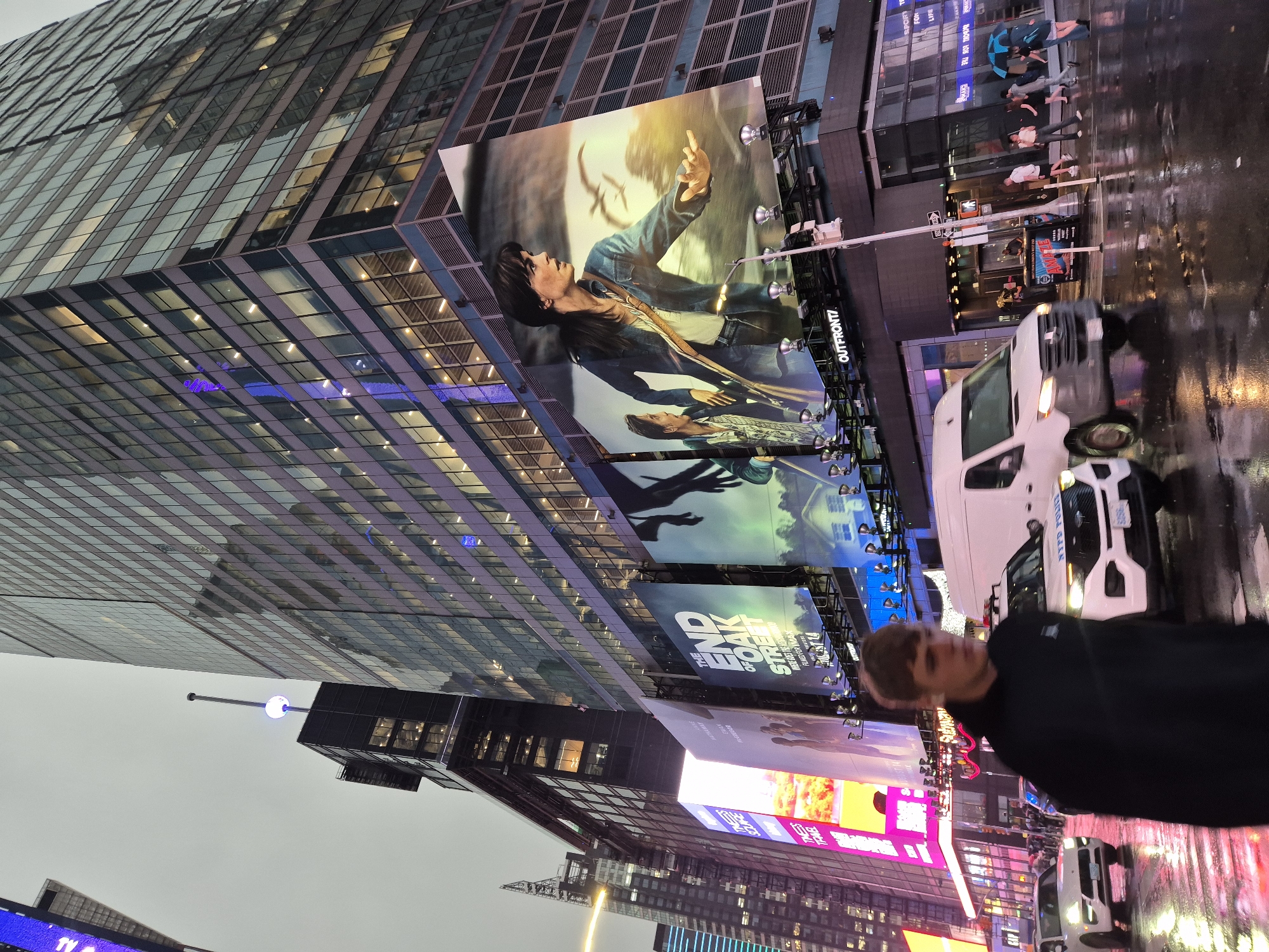 Rainy evening in Times Square, neon reflecting off wet streets