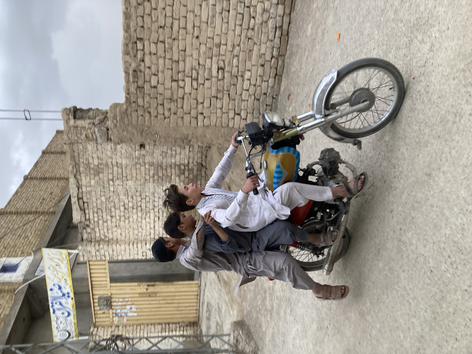 Two girls photographed near calligraphic wall in Quetta