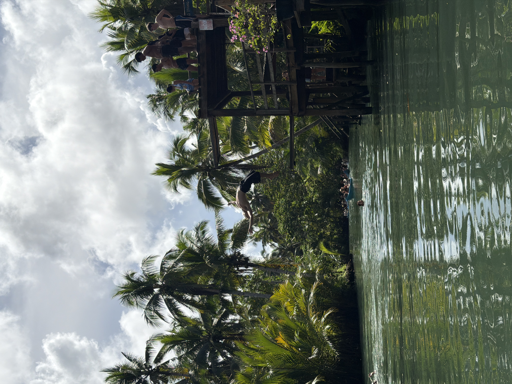 Man dives from wooden structure in Dapa, Philippines