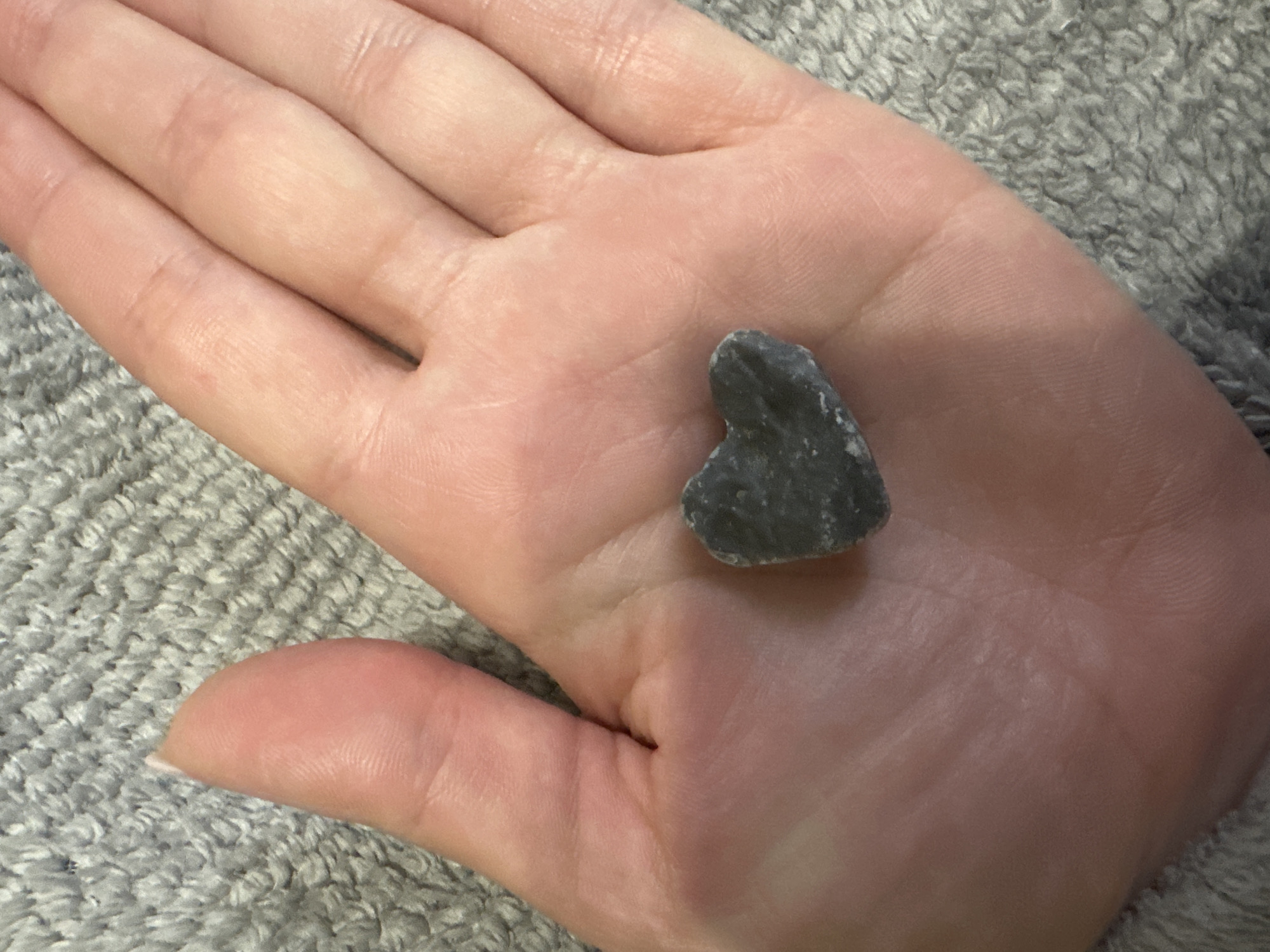 Private bedroom moment with heart-shaped stone and gift documented
