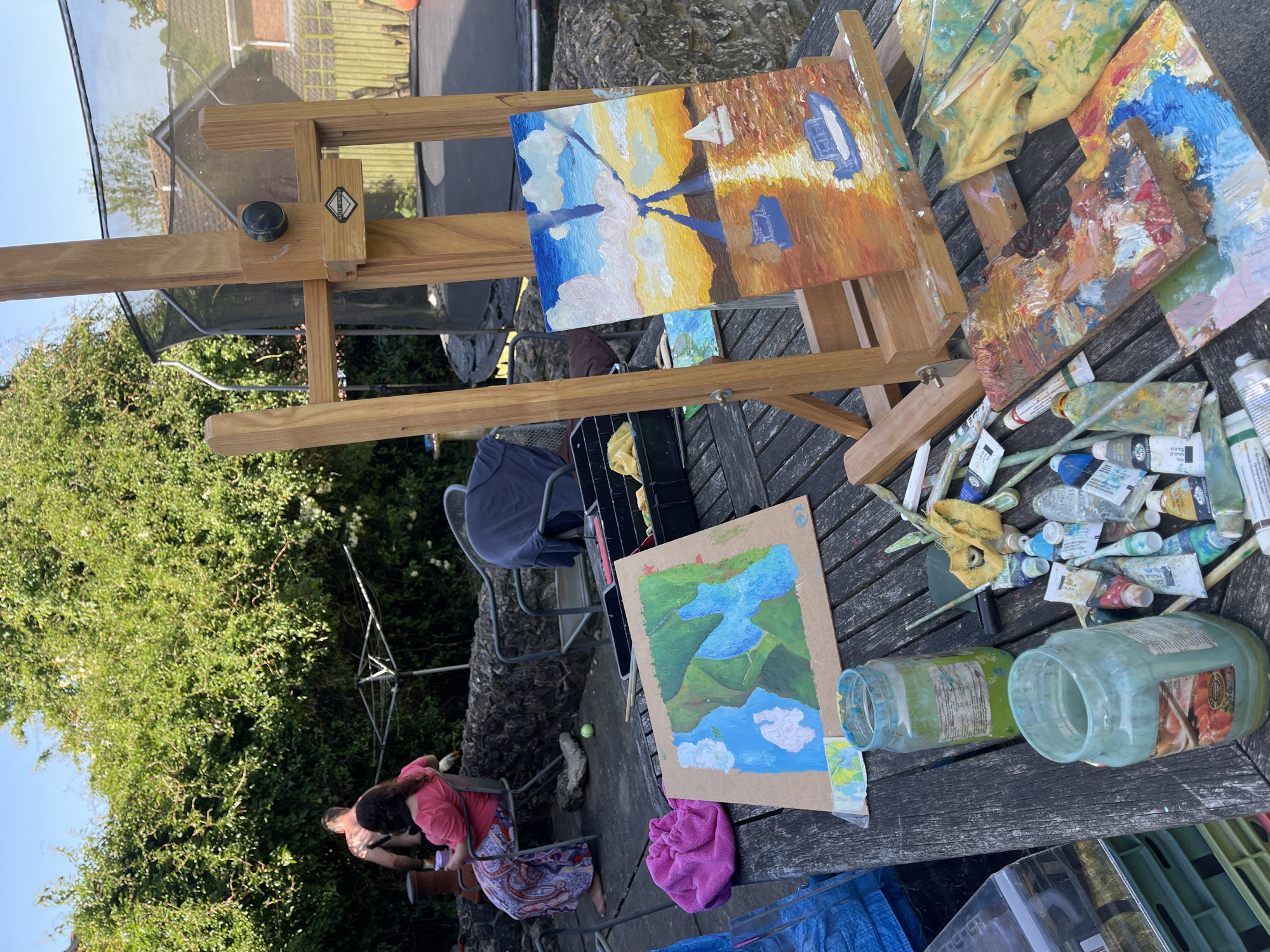 Artist paints boats outdoors while gardener trims bushes in Maidstone