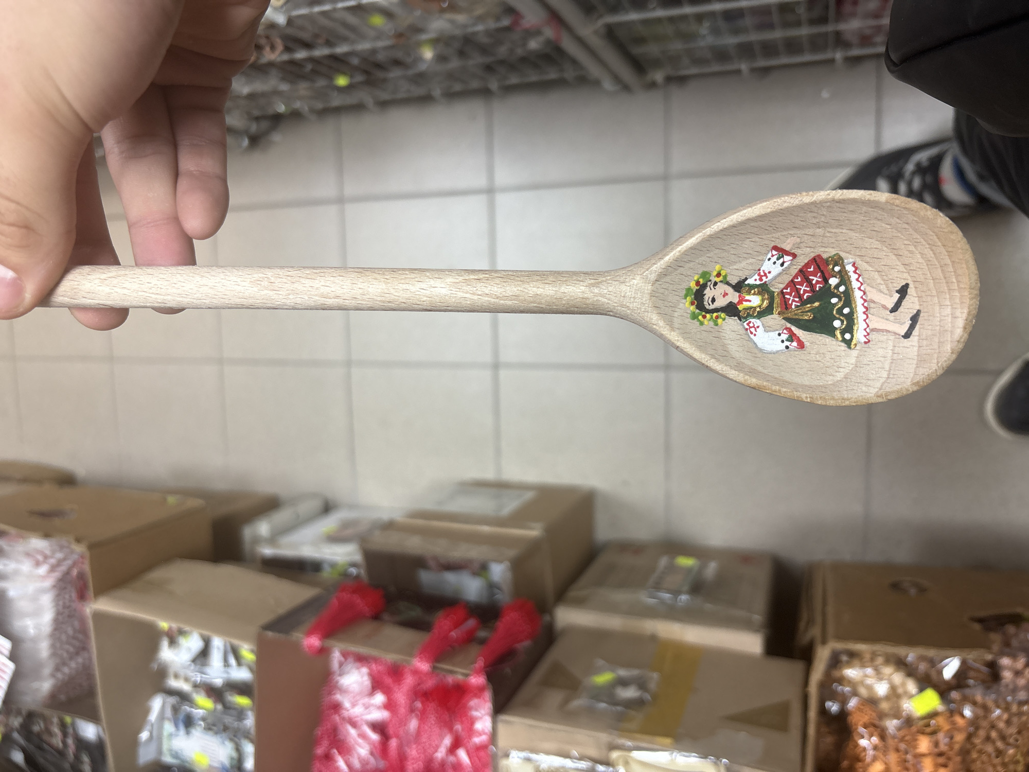 Traditional Bulgarian figurine displayed on wooden spoon in Sofia shop