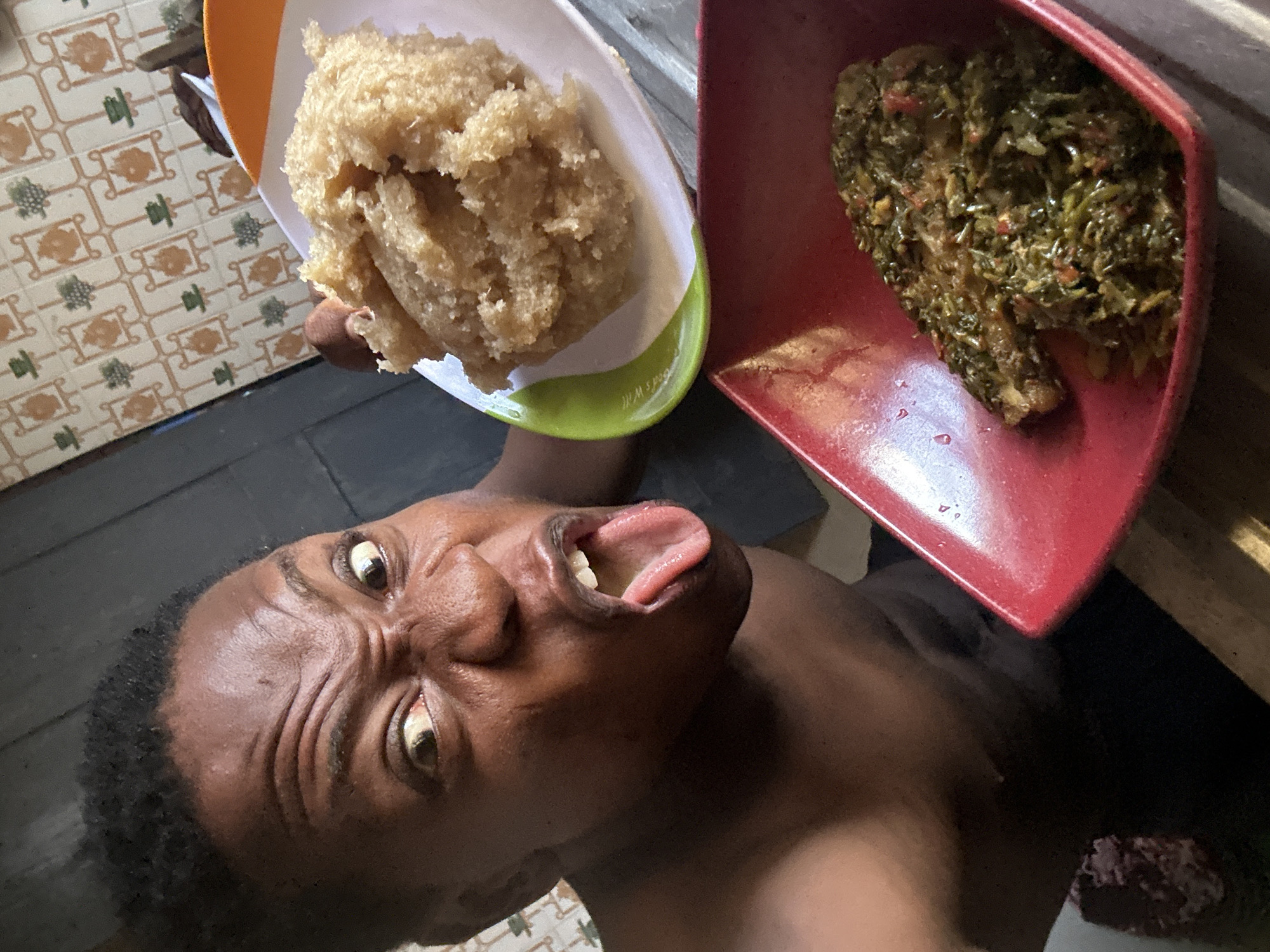 Person eating traditional meal while children gather in nearby schoolyard