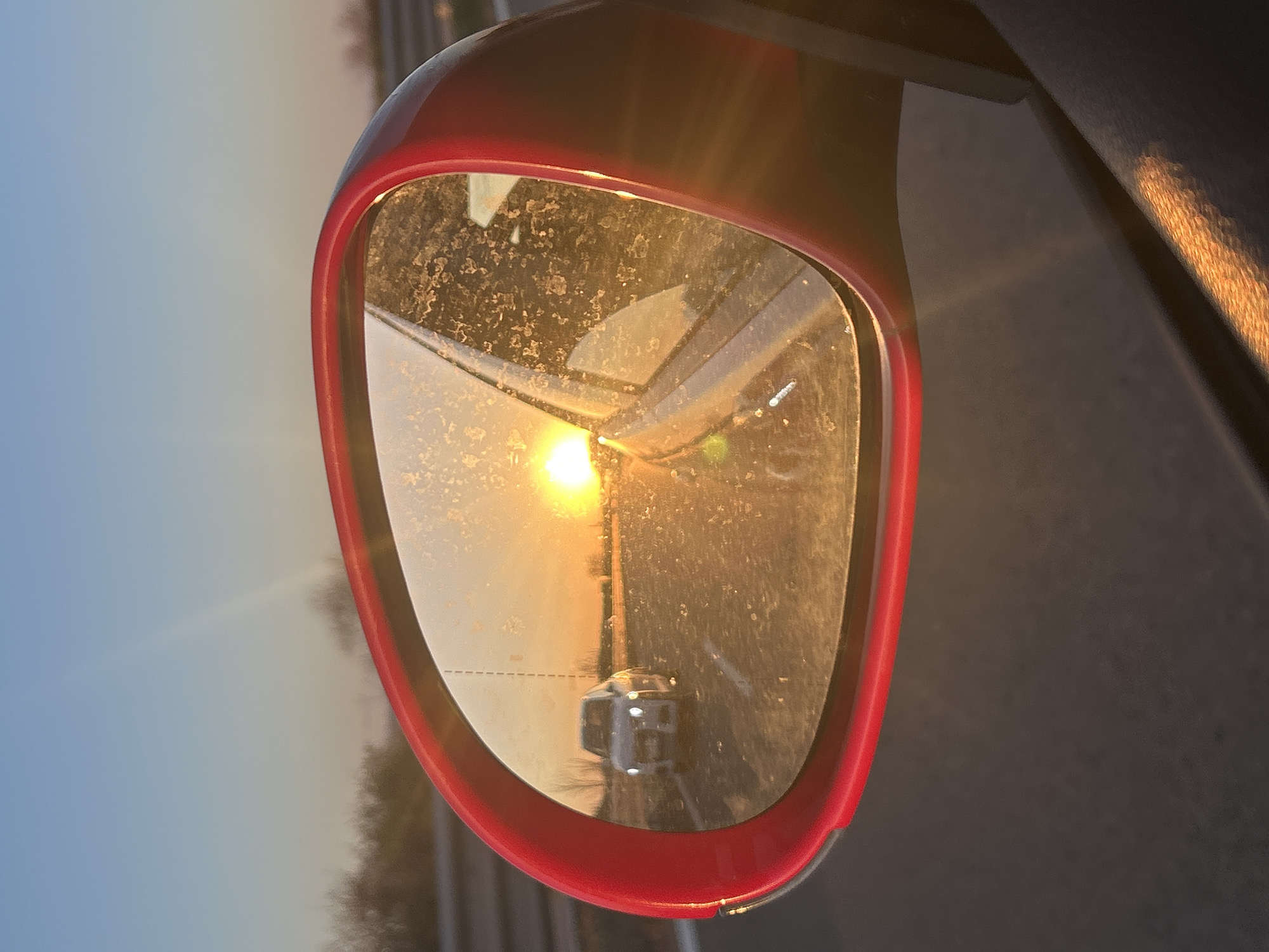 Driver captures sun-drenched road reflection in car mirror, Bulgaria