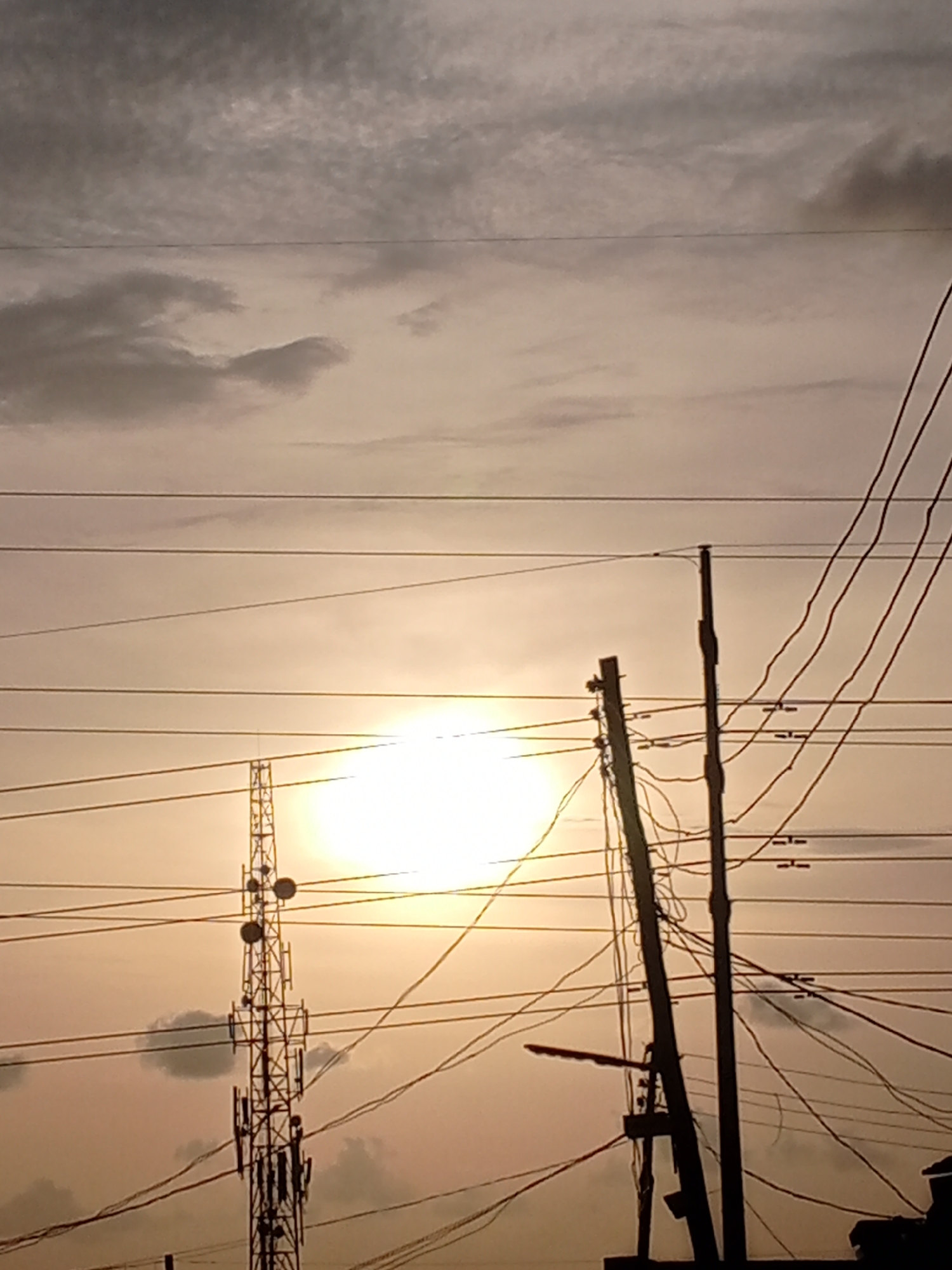 Urban sunset captured with power lines and cell tower