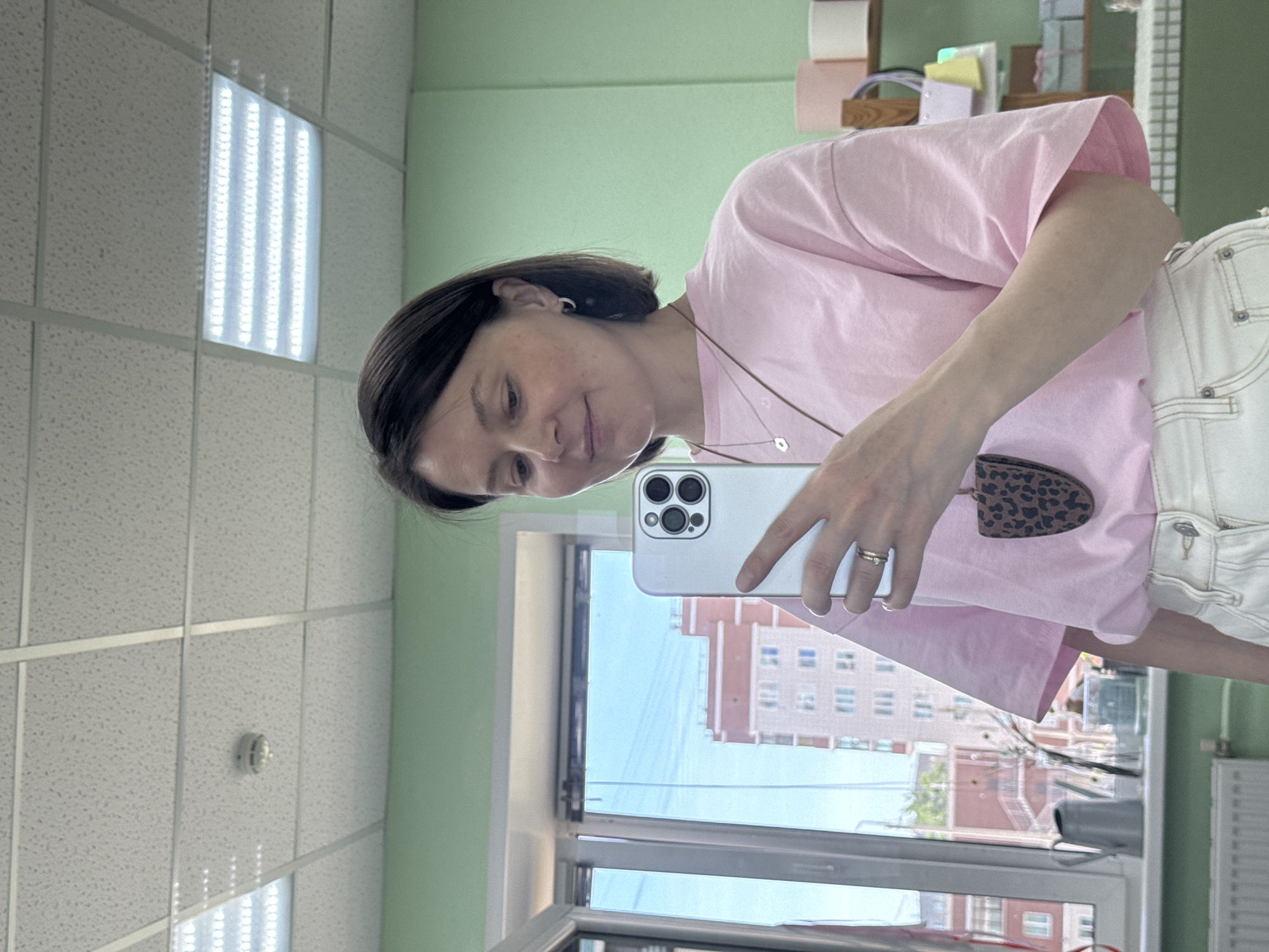 Woman takes selfies in Izhevsk room with green walls