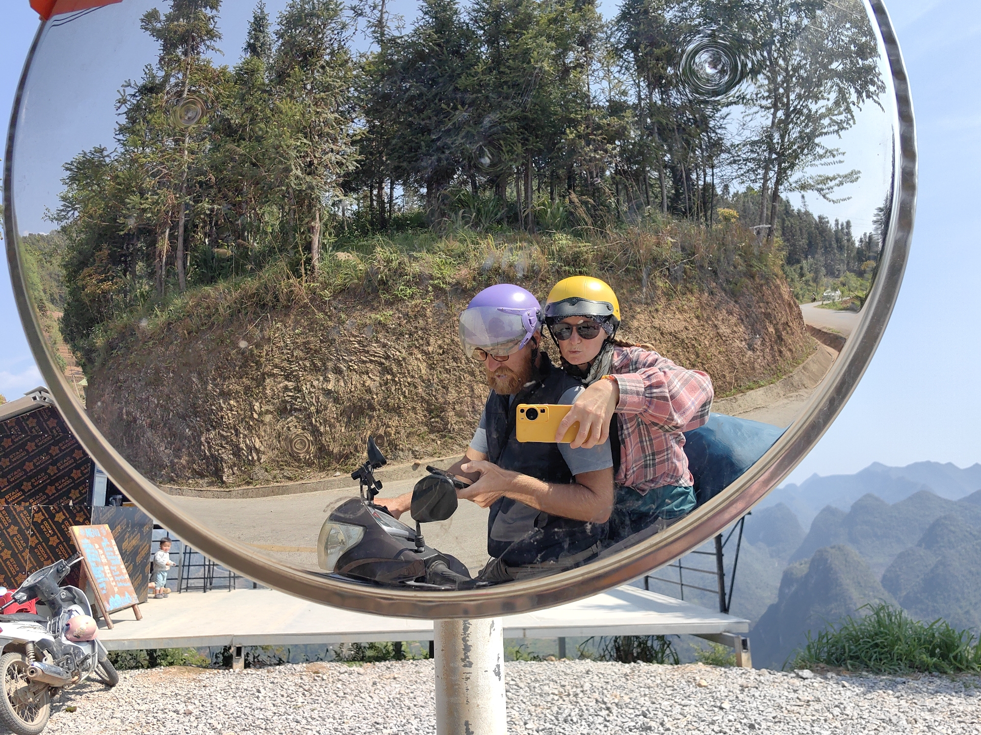 Couple takes mirror selfie on scooter in Vietnam