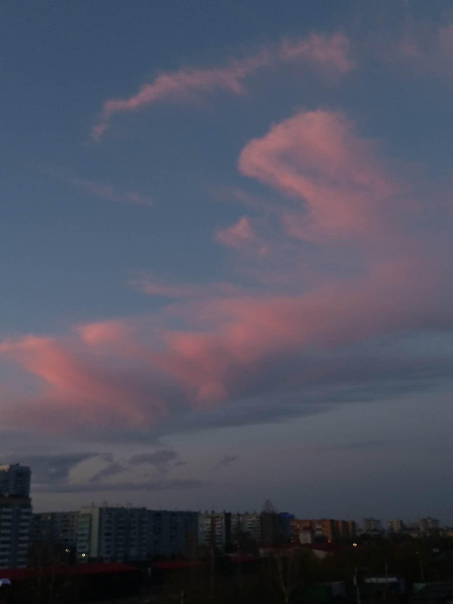 Dusk cityscape captured in Krasnoyarsk showing pink clouds over apartments