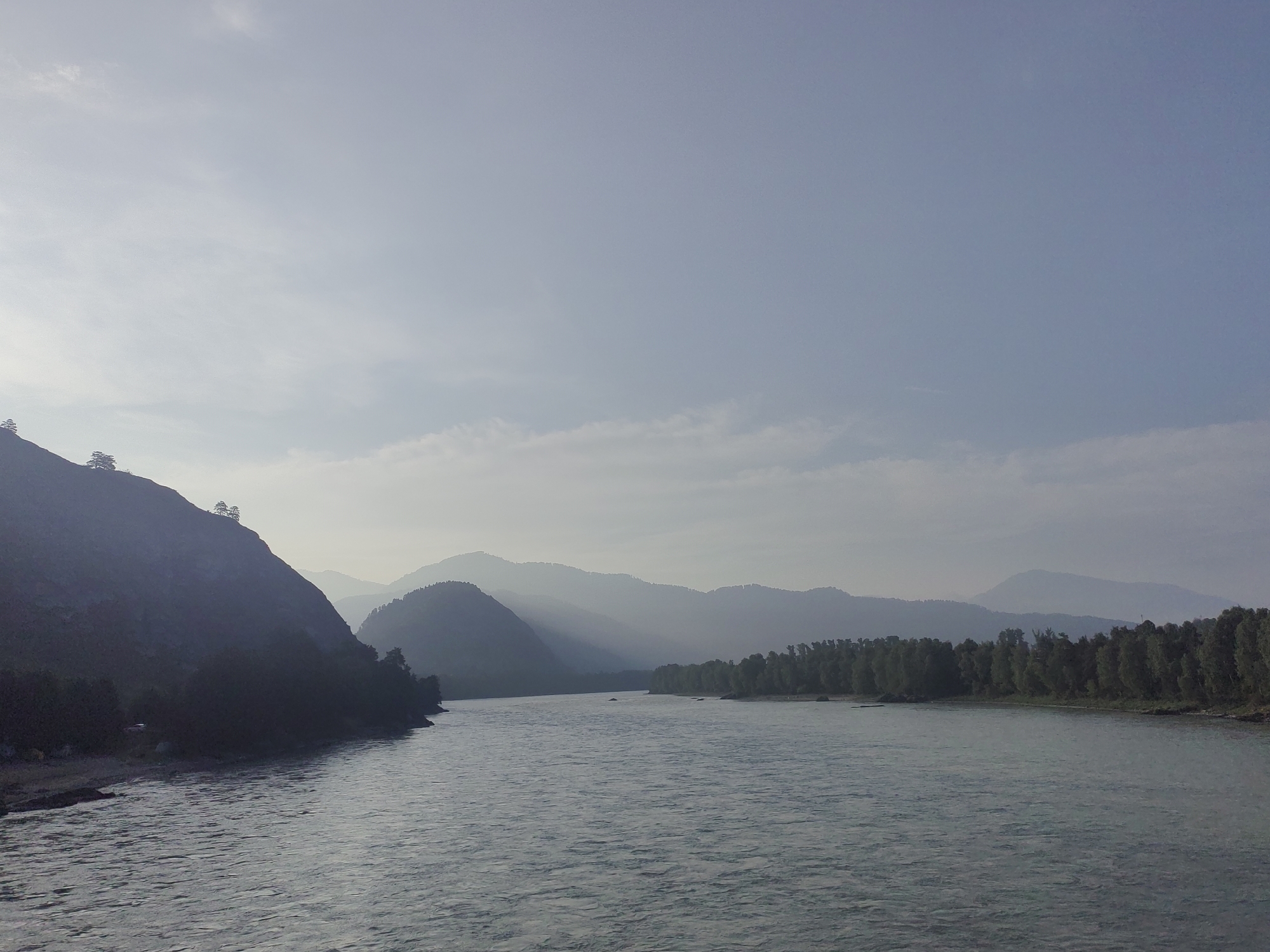Calm river winding through hazy mountain terrain in Anos, Russia