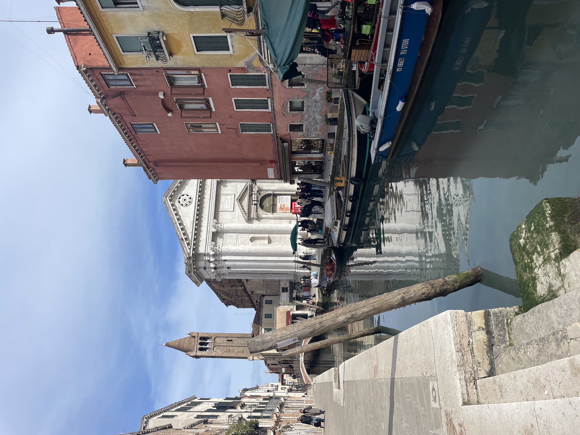 Tourists capture classic Venice canal scenes during midday sightseeing