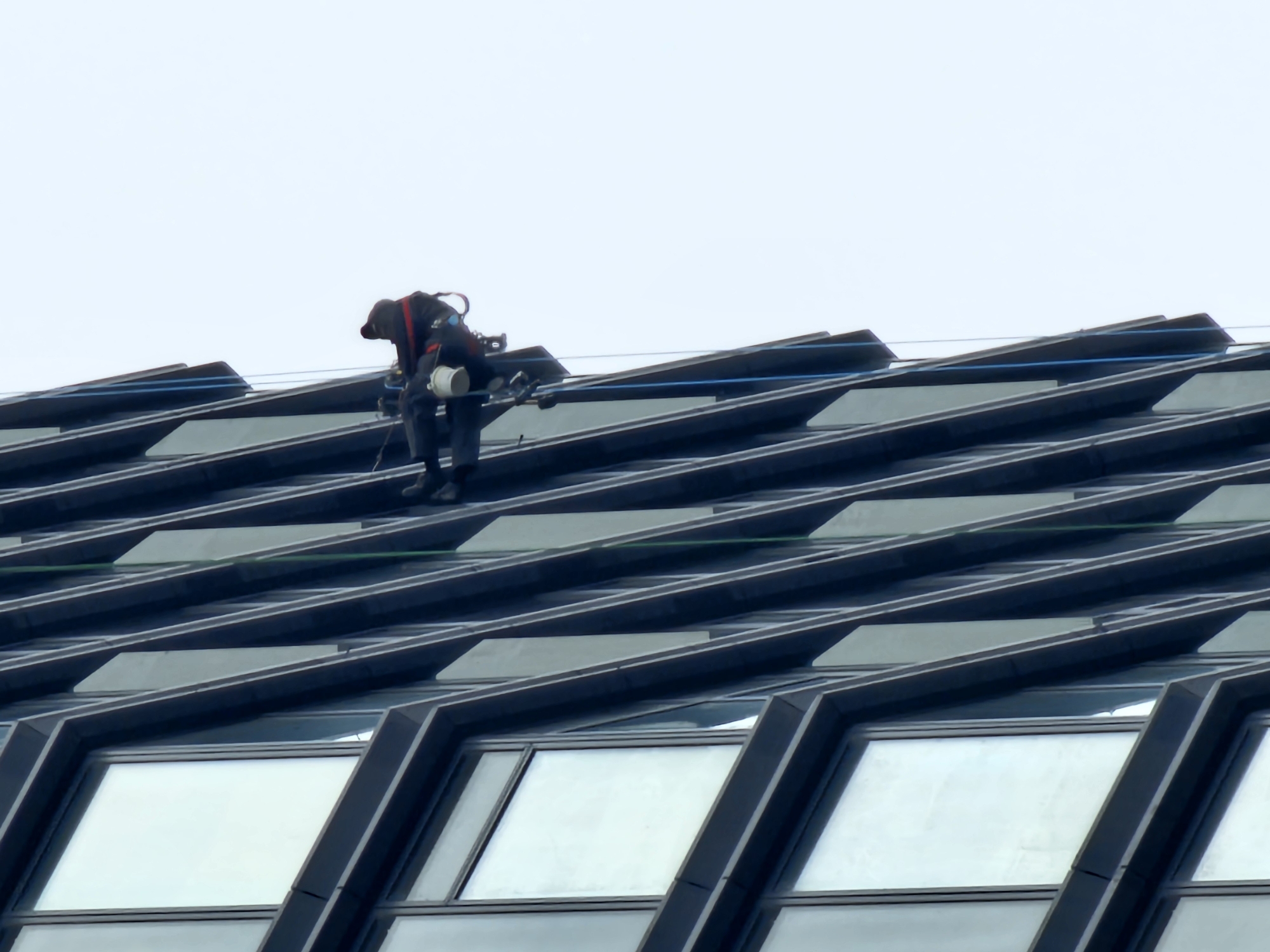Workers rappel down Moscow building during maintenance operations