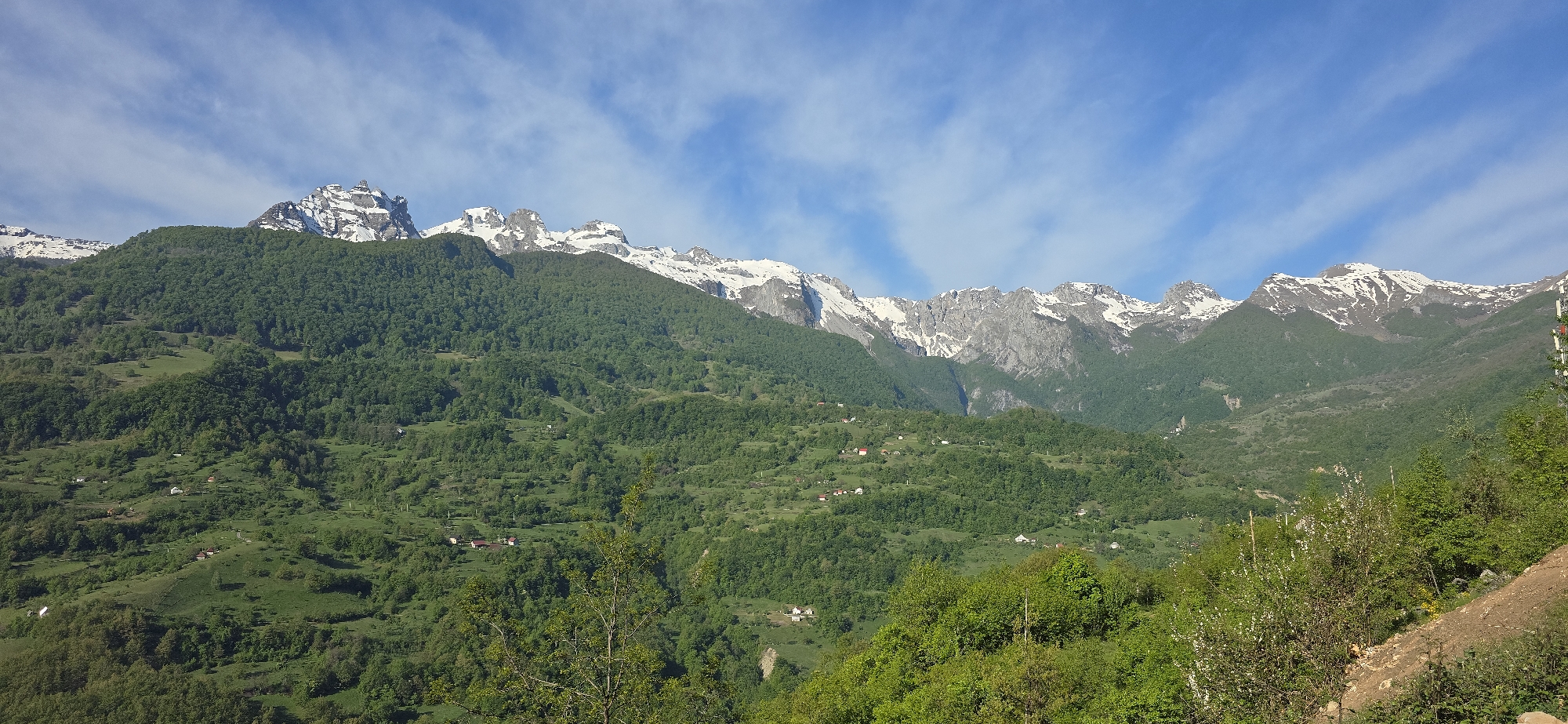 Snow-capped peaks filmed above green forests in Montenegro morning