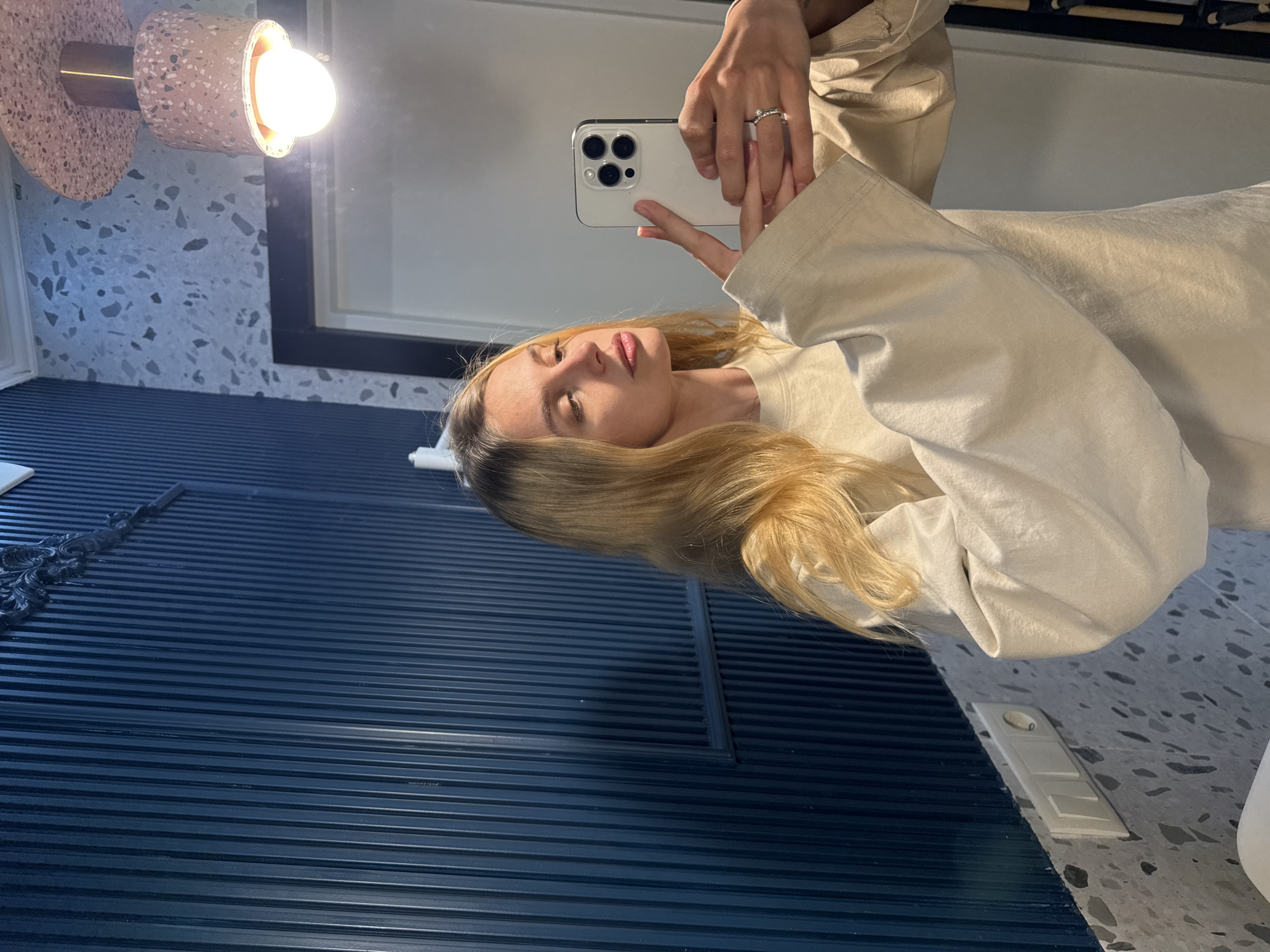 Woman takes bathroom selfies with white smartphone Friday evening