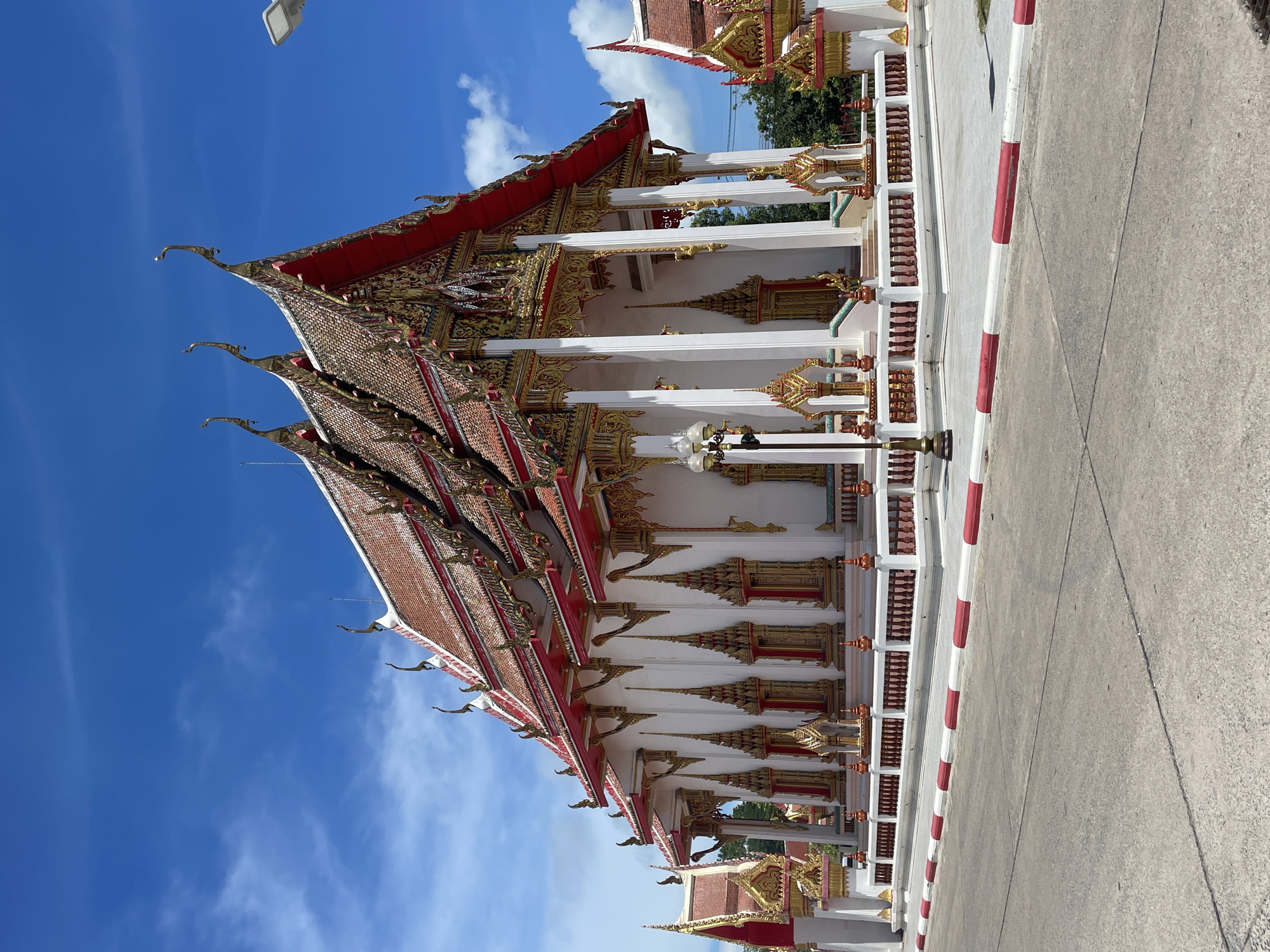 Morning visitors photograph ornate Wat Chalong temple in Thailand