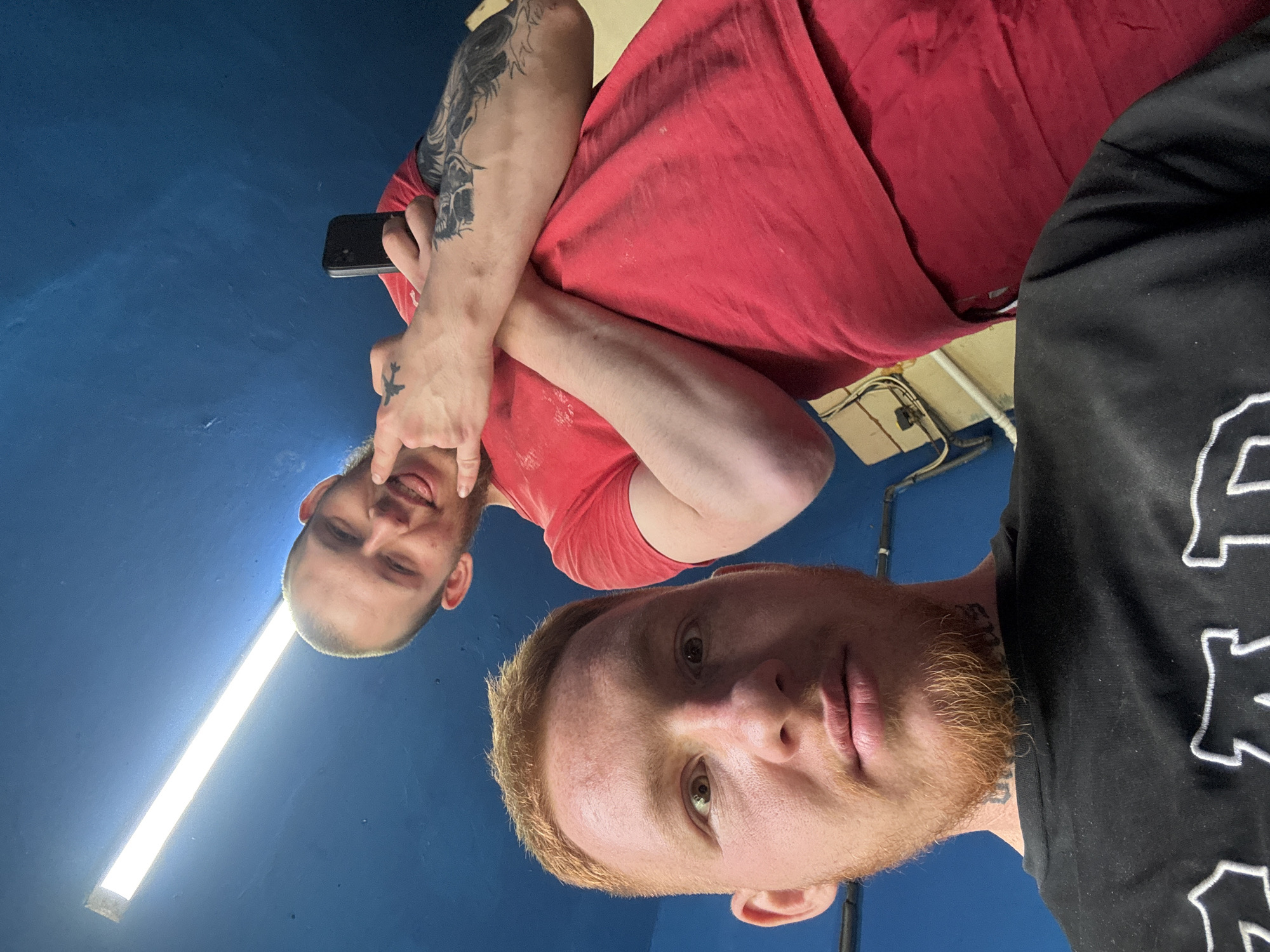 Two men take selfies indoors in Makiivka, Ukraine