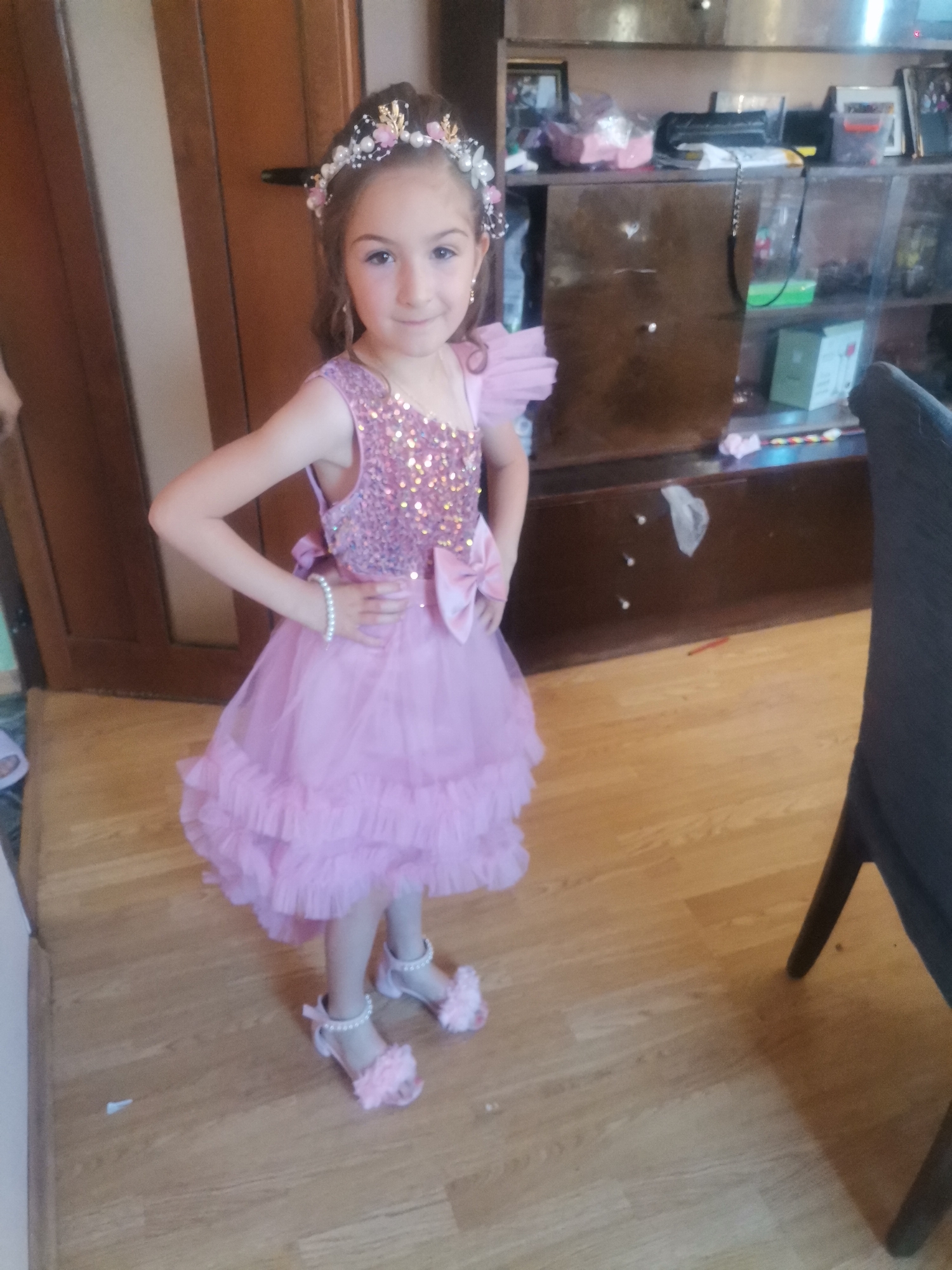 Young girl in pink dress observed indoors