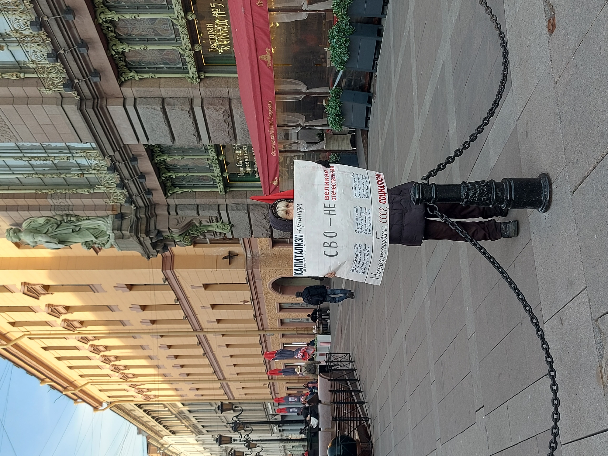 Anti-capitalism protester demonstrates in Saint Petersburg amid motorcycle traffic