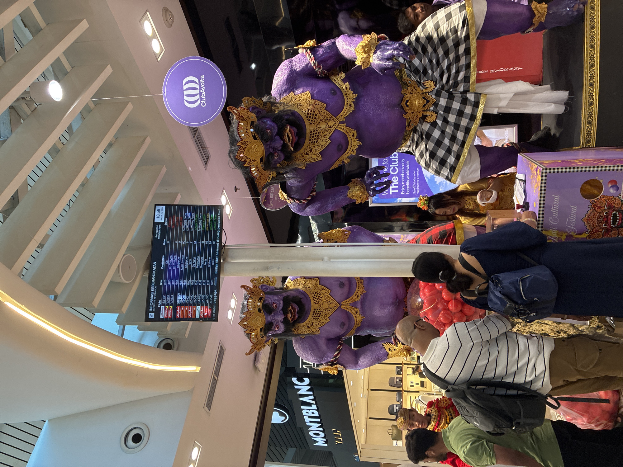 Kuta airport terminal observed with Balinese statues, duty-free shops