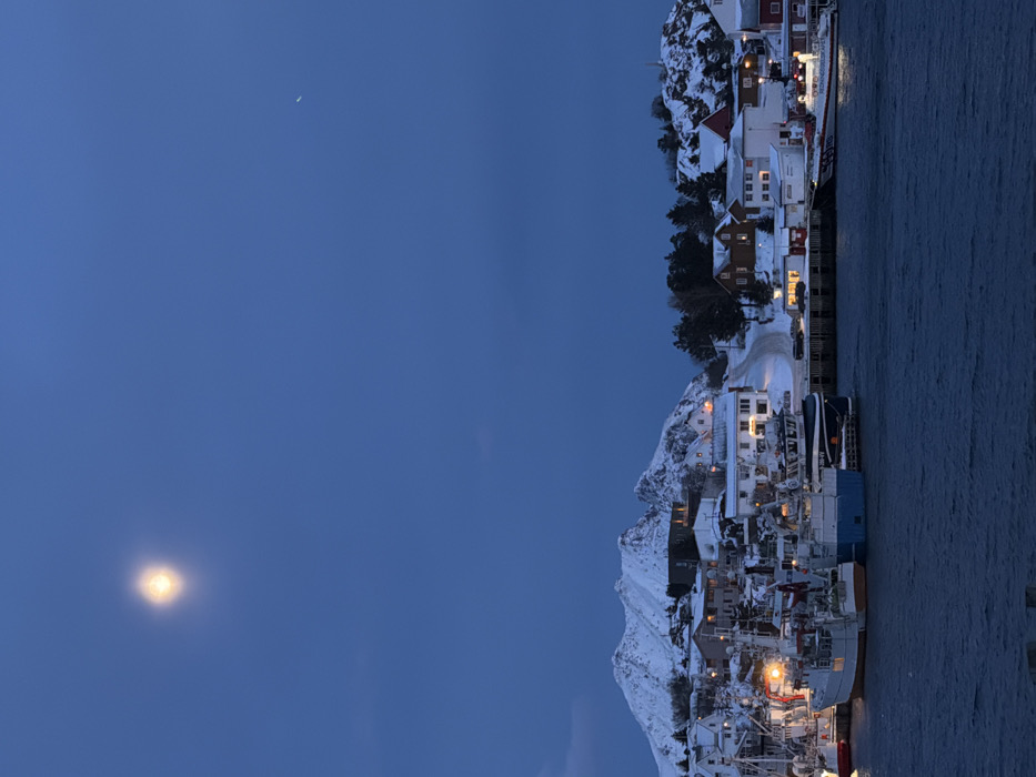 Dusk captures snow-covered Ballstad coastal town in evening light