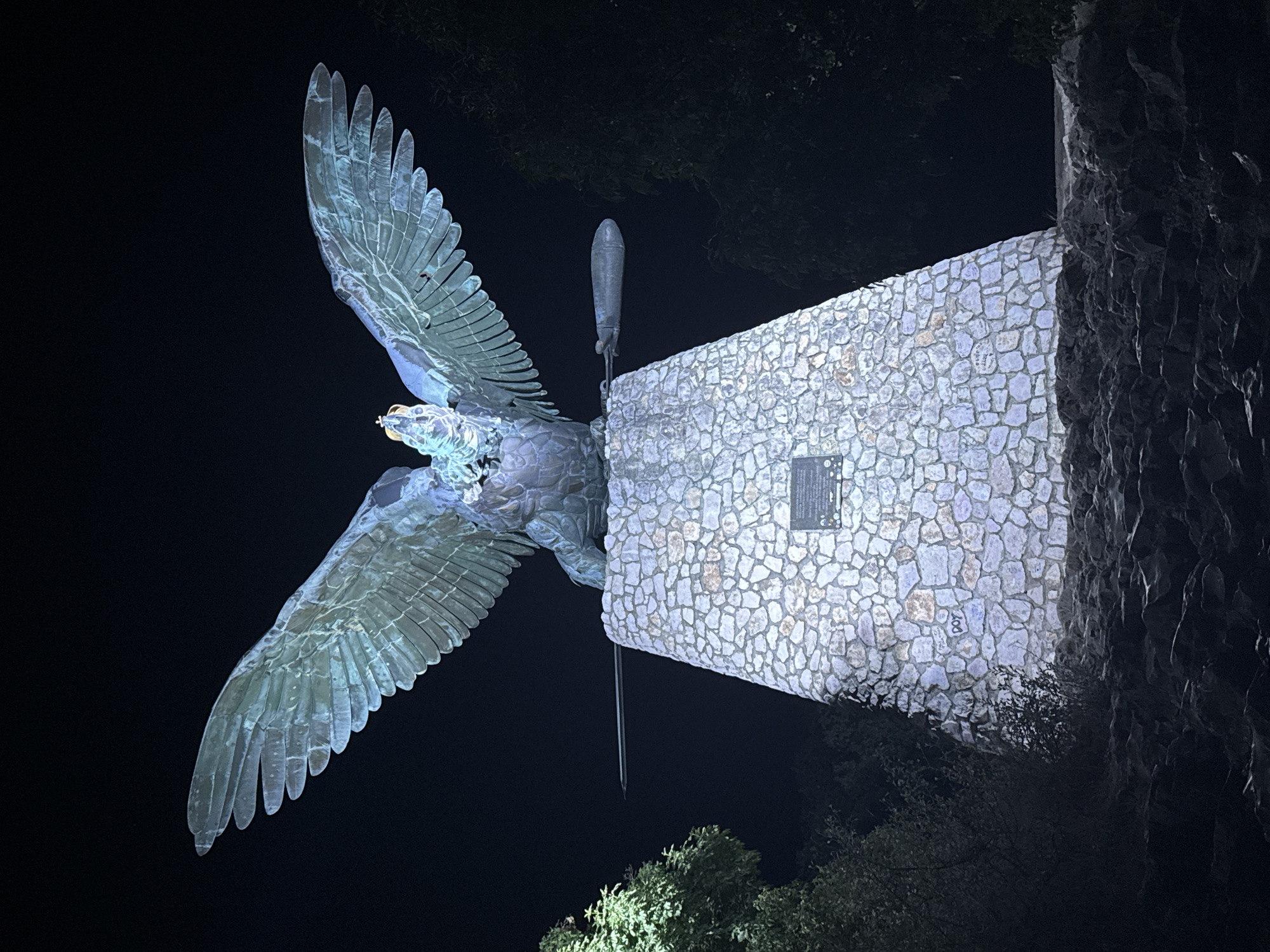 Bronze eagle monument illuminated at night