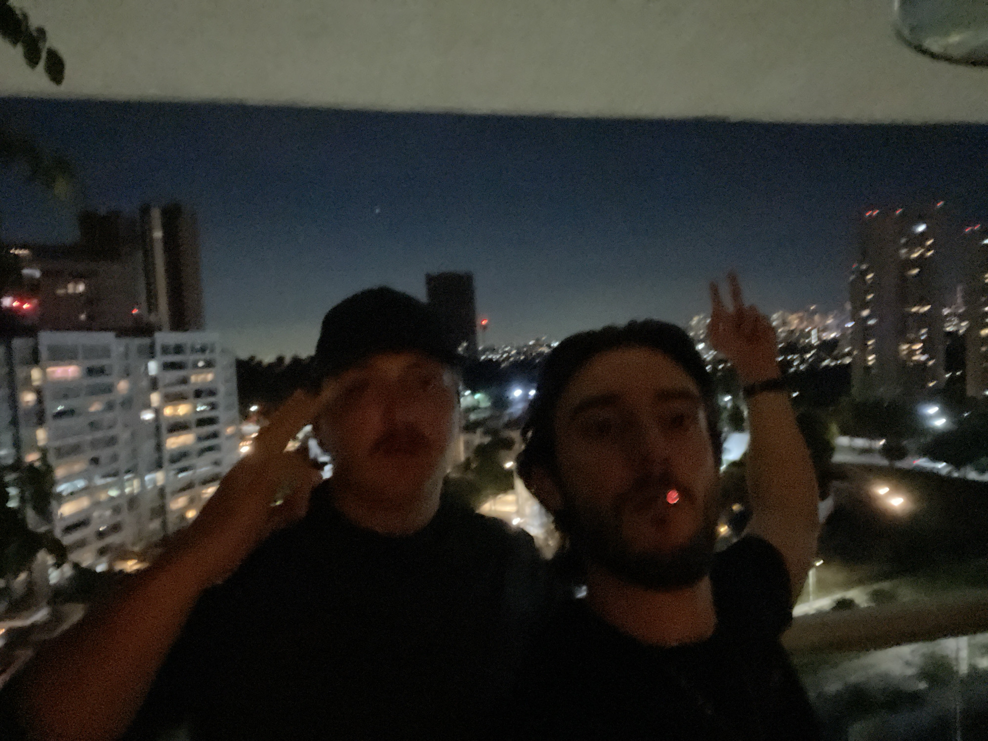 Two men photograph nighttime moment on Huixquilucan balcony