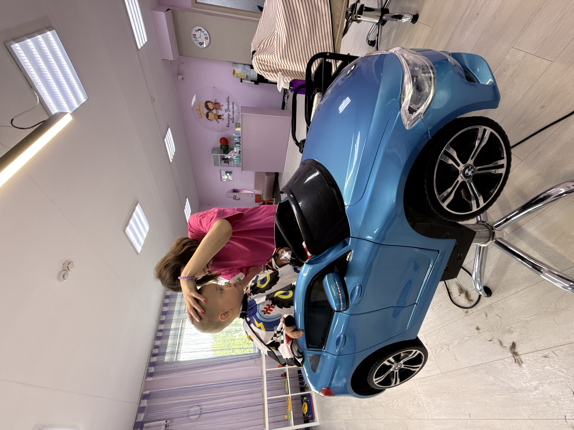 Kids' salon haircut in a blue toy car, multiple angles