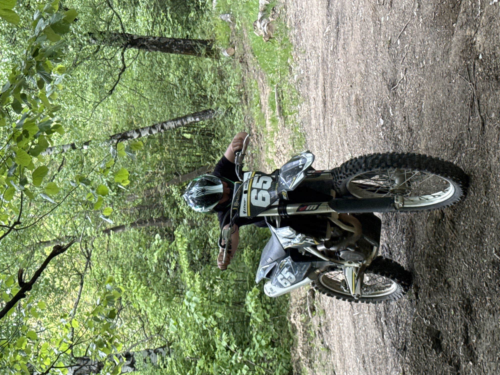 Motorcyclist rides through forest near Berkovitsa welcome sign