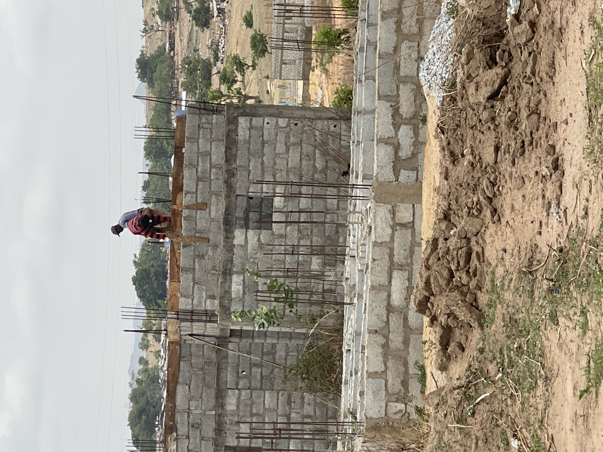 Construction workers build concrete block structures in Angwan Sayawa